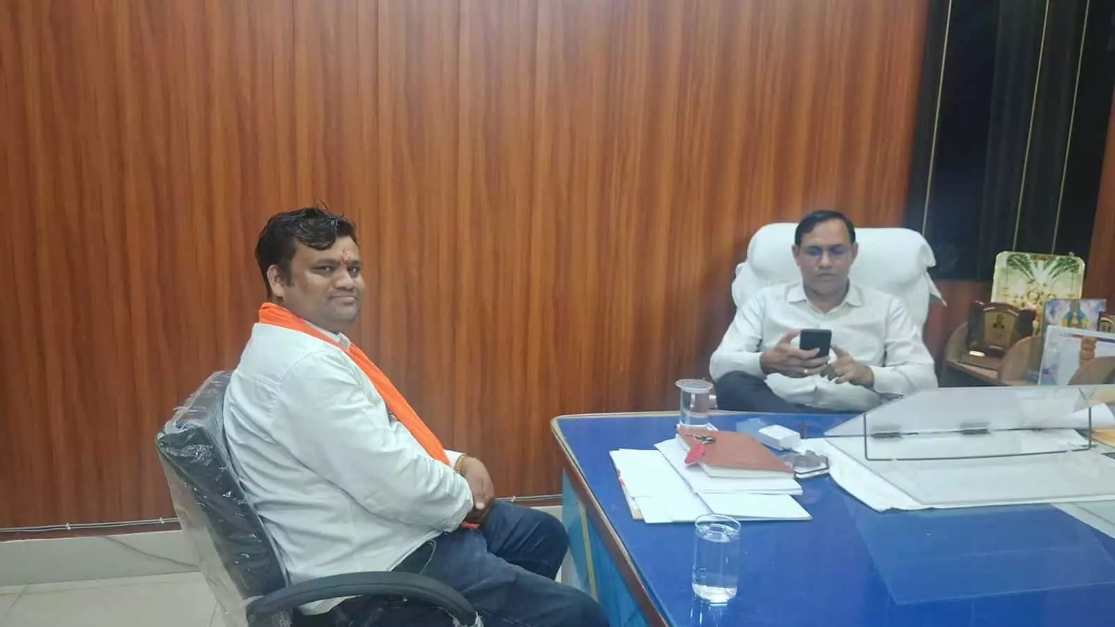 कार्यालय की टेबल के पास कुर्सी पर बैठे समाजसेवी राहुल गोयल और मोबाइल देखते SDM विनोद सिंह गोदारा। कार्यालय की टेबल के पास कुर्सी पर बैठे समाजसेवी राहुल गोयल और मोबाइल देखते SDM विनोद सिंह गोदारा।