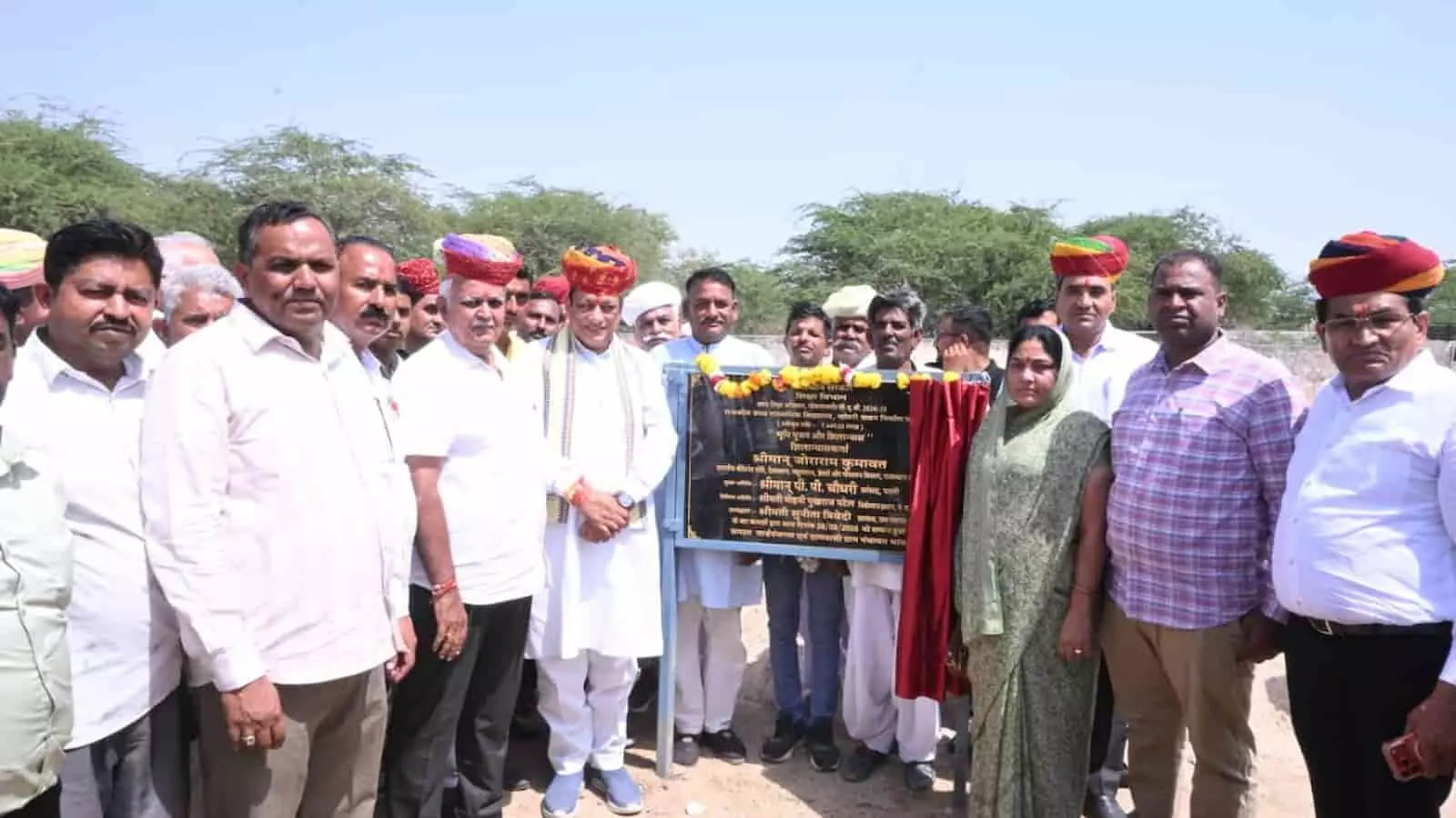 तस्वीर में दिख रही शिलान्यास पट्टिका का अनावरण कर मंत्री जोराराम कुमावत और ग्रामीण समूह में खड़े हैं। तस्वीर में दिख रही शिलान्यास पट्टिका का अनावरण कर मंत्री जोराराम कुमावत और ग्रामीण समूह में खड़े हैं।