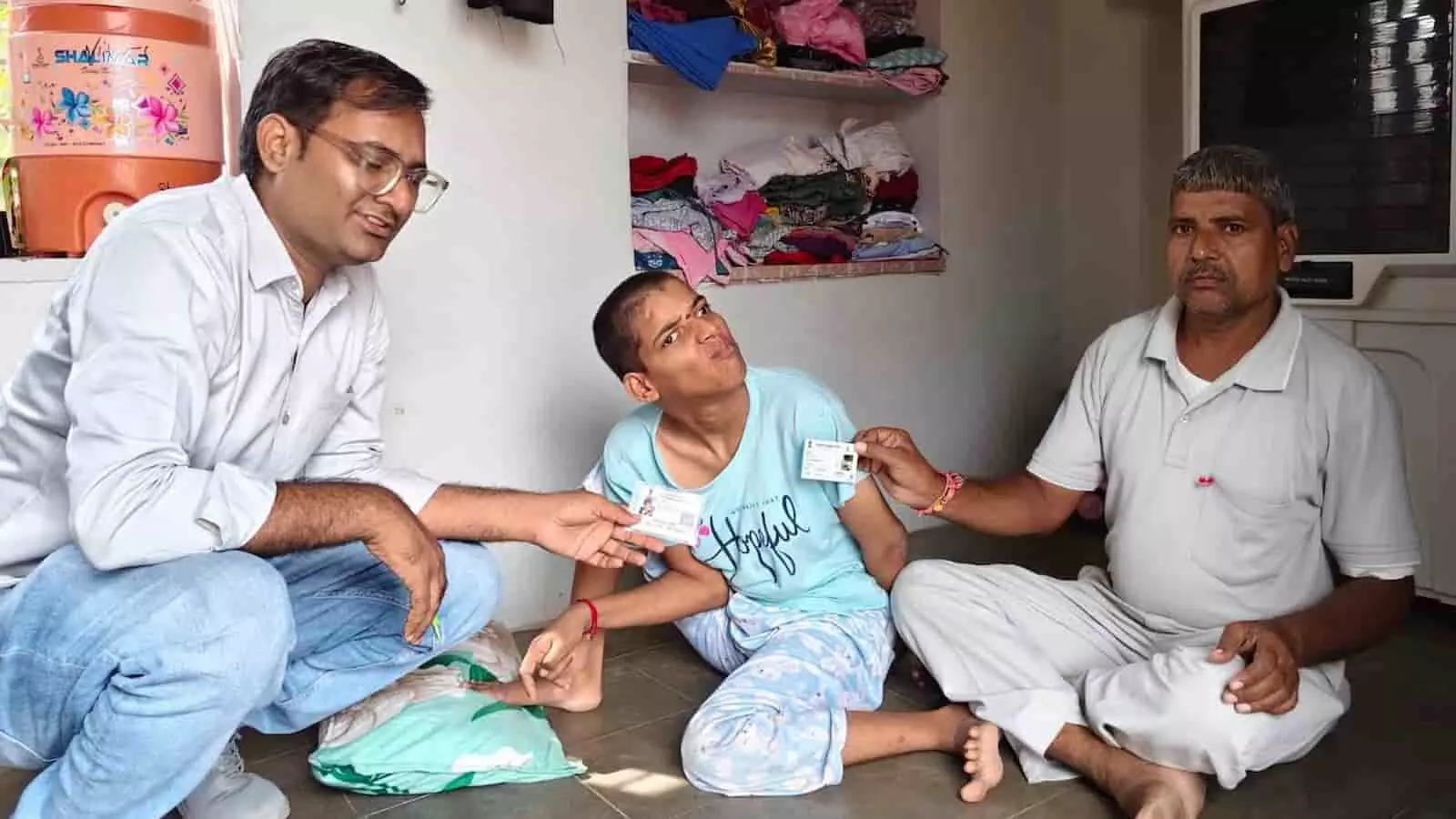 तस्वीर में बाईं ओर बैठे अधिकारी, बीच में दिव्यांग युवक और दाईं ओर बैठे व्यक्ति पहचान पत्र दिखा रहे हैं। तस्वीर में बाईं ओर बैठे अधिकारी, बीच में दिव्यांग युवक और दाईं ओर बैठे व्यक्ति पहचान पत्र दिखा रहे हैं।