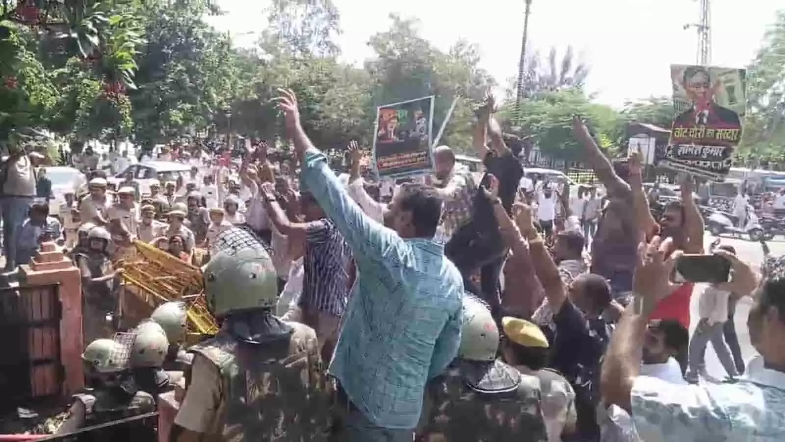 तस्वीर में पुलिसकर्मियों के सामने हाथ उठाकर नारेबाजी करते और पोस्टर लहराते हुए प्रदर्शनकारी दिखाई दे रहे हैं। तस्वीर में पुलिसकर्मियों के सामने हाथ उठाकर नारेबाजी करते और पोस्टर लहराते हुए प्रदर्शनकारी दिखाई दे रहे हैं।
