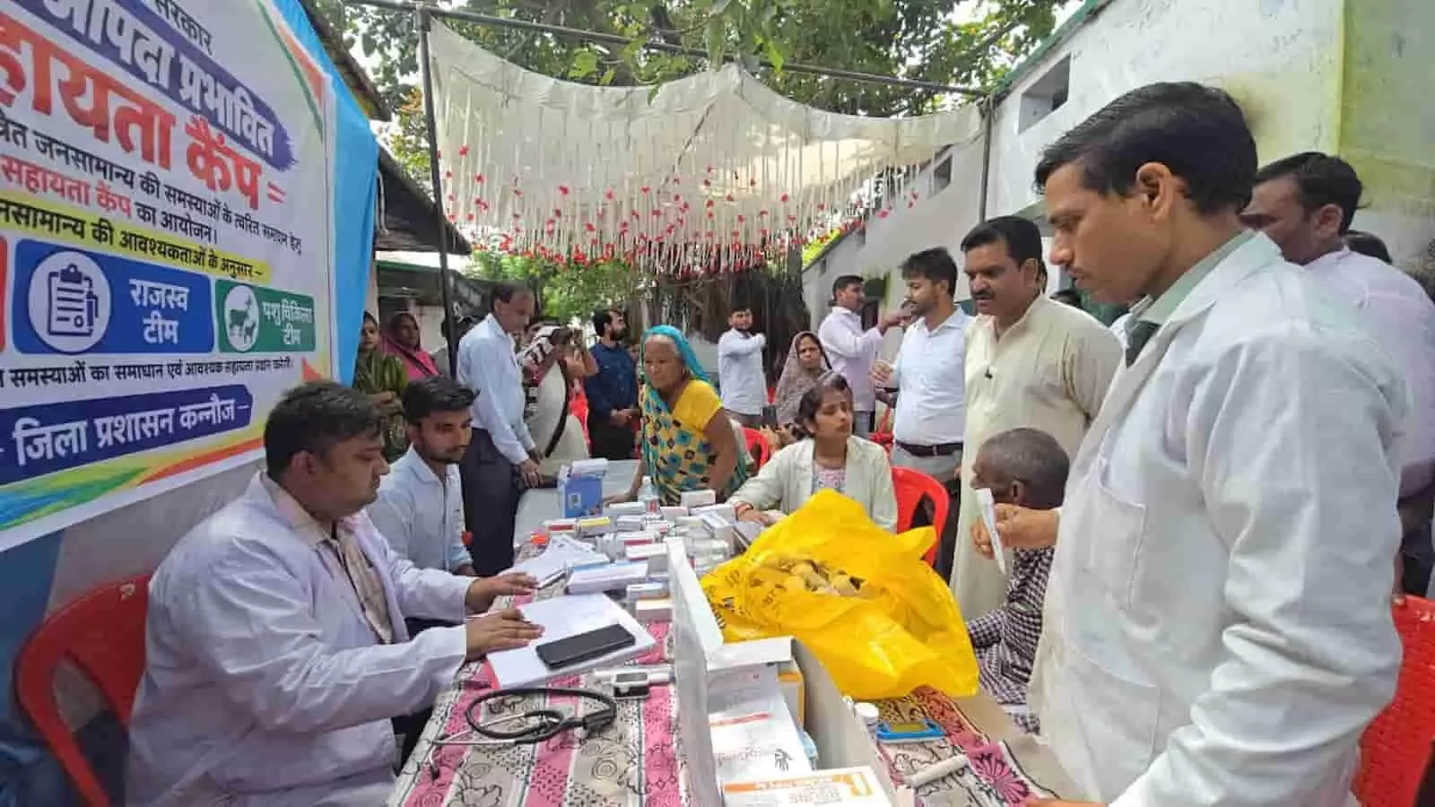 तस्वीर में दिख रही मेज पर दवाइयां रखी हैं, जहां स्वास्थ्यकर्मी मरीजों की जांच कर रहे हैं। तस्वीर में दिख रही मेज पर दवाइयां रखी हैं, जहां स्वास्थ्यकर्मी मरीजों की जांच कर रहे हैं।