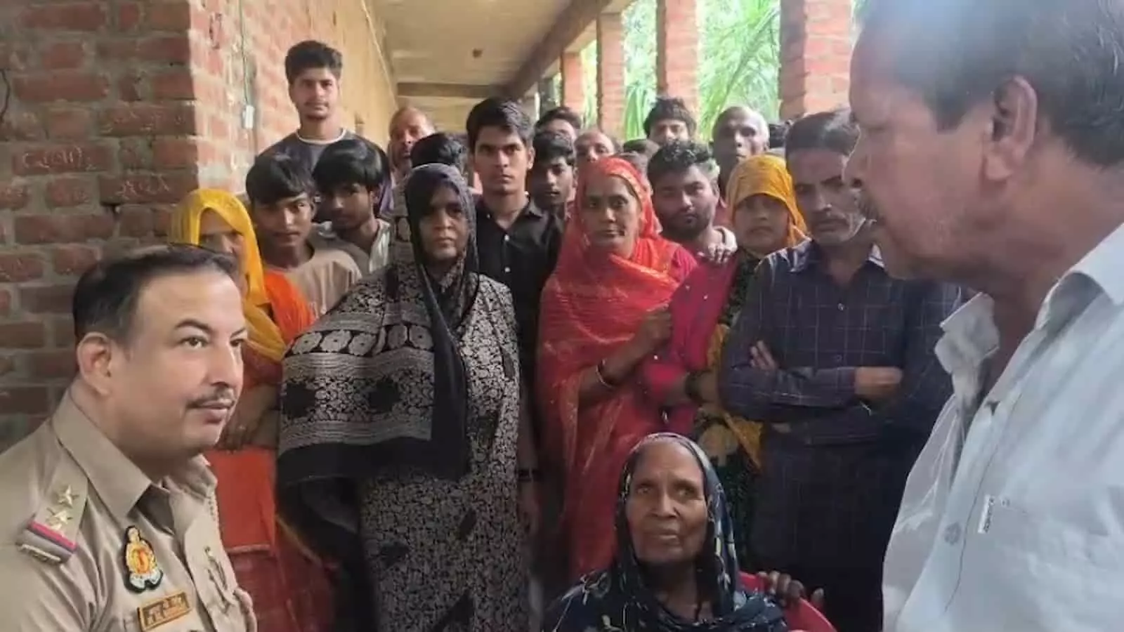 तस्वीर में बाईं ओर खड़े पुलिस अधिकारी स्कूल के गलियारे में मौजूद लोगों से बातचीत करते दिख रहे हैं। तस्वीर में बाईं ओर खड़े पुलिस अधिकारी स्कूल के गलियारे में मौजूद लोगों से बातचीत करते दिख रहे हैं।