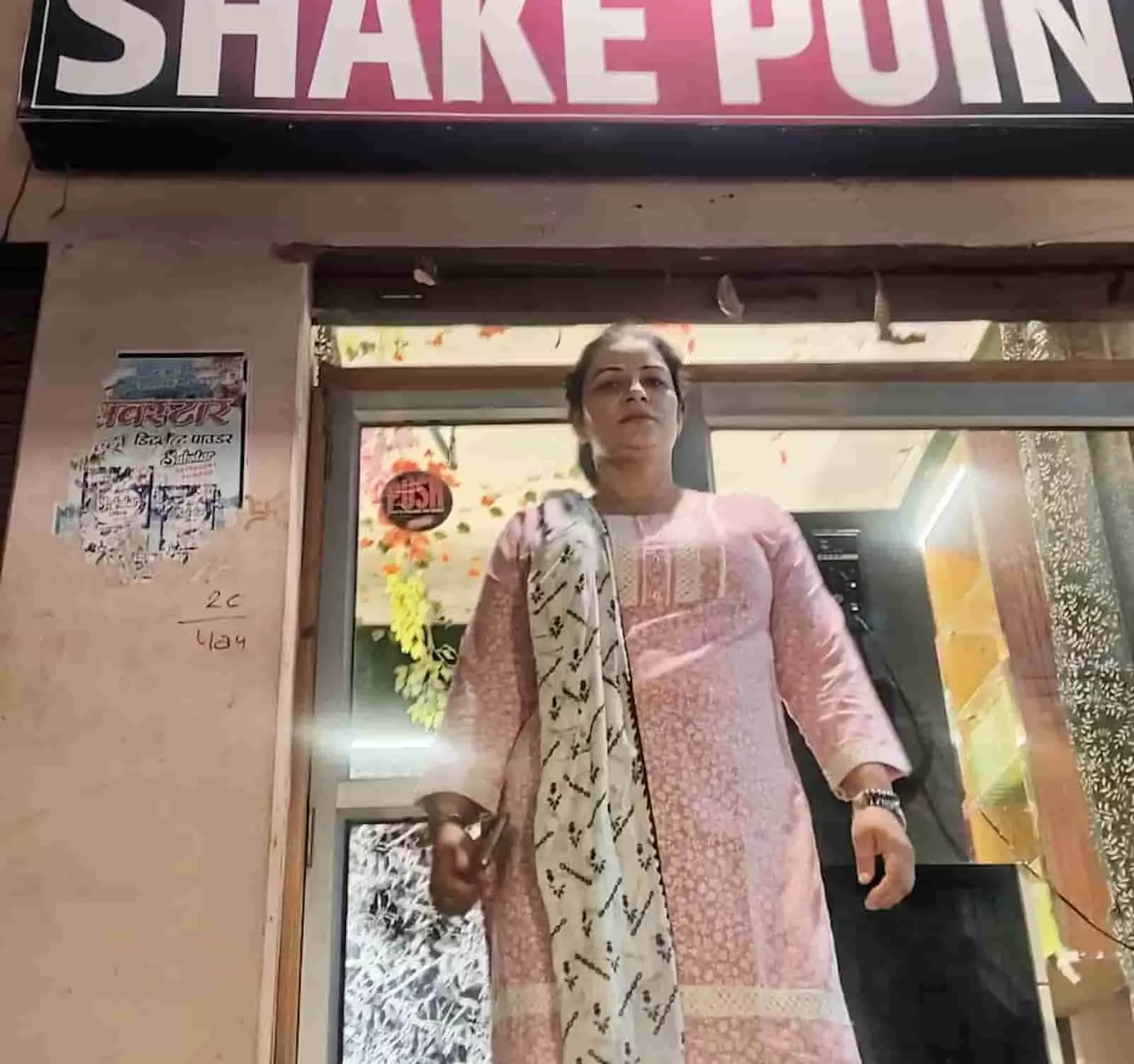 तस्वीर में दिख रही महिला गुलाबी सूट पहने एटा में अपनी जूस की दुकान के सामने खड़ी हैं। तस्वीर में दिख रही महिला गुलाबी सूट पहने एटा में अपनी जूस की दुकान के सामने खड़ी हैं।