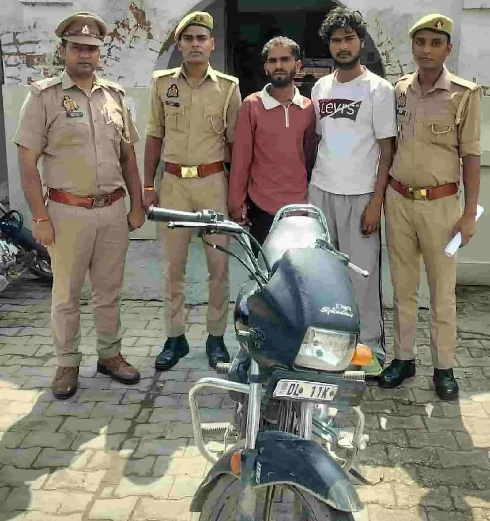 तस्वीर में पुलिस अधिकारियों के साथ दो आरोपी चोरी की मोटरसाइकिल के पीछे खड़े हैं। तस्वीर में पुलिस अधिकारियों के साथ दो आरोपी चोरी की मोटरसाइकिल के पीछे खड़े हैं।