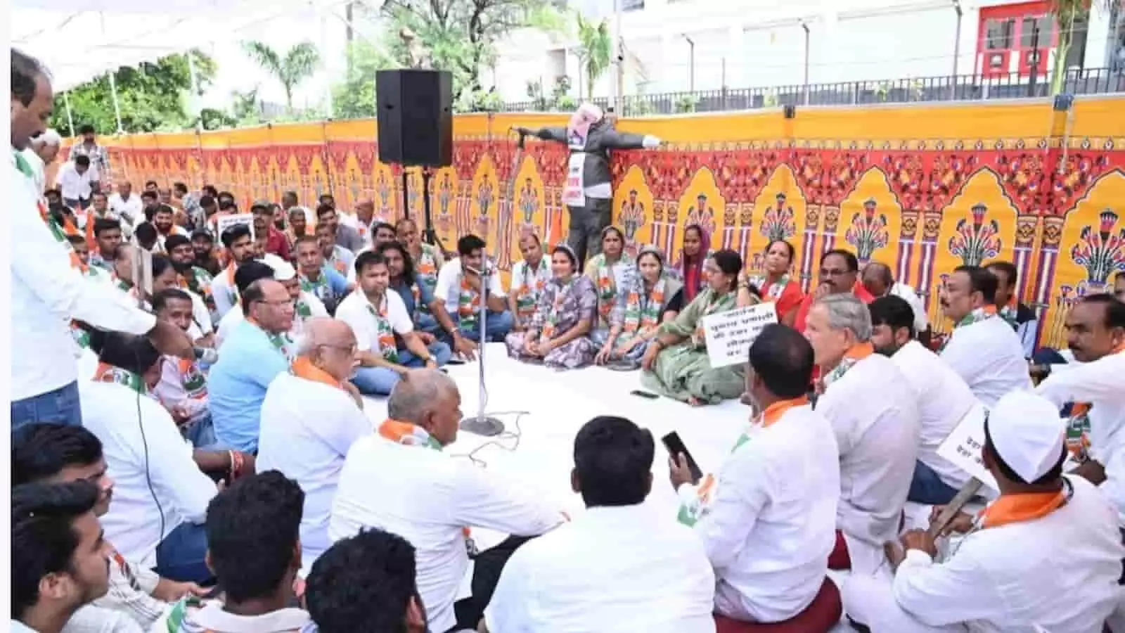तस्वीर में दिख रही कांग्रेस कार्यकर्ता पंडाल के नीचे जमीन पर बैठकर विरोध-प्रदर्शन कर रहे हैं। तस्वीर में दिख रही कांग्रेस कार्यकर्ता पंडाल के नीचे जमीन पर बैठकर विरोध-प्रदर्शन कर रहे हैं।