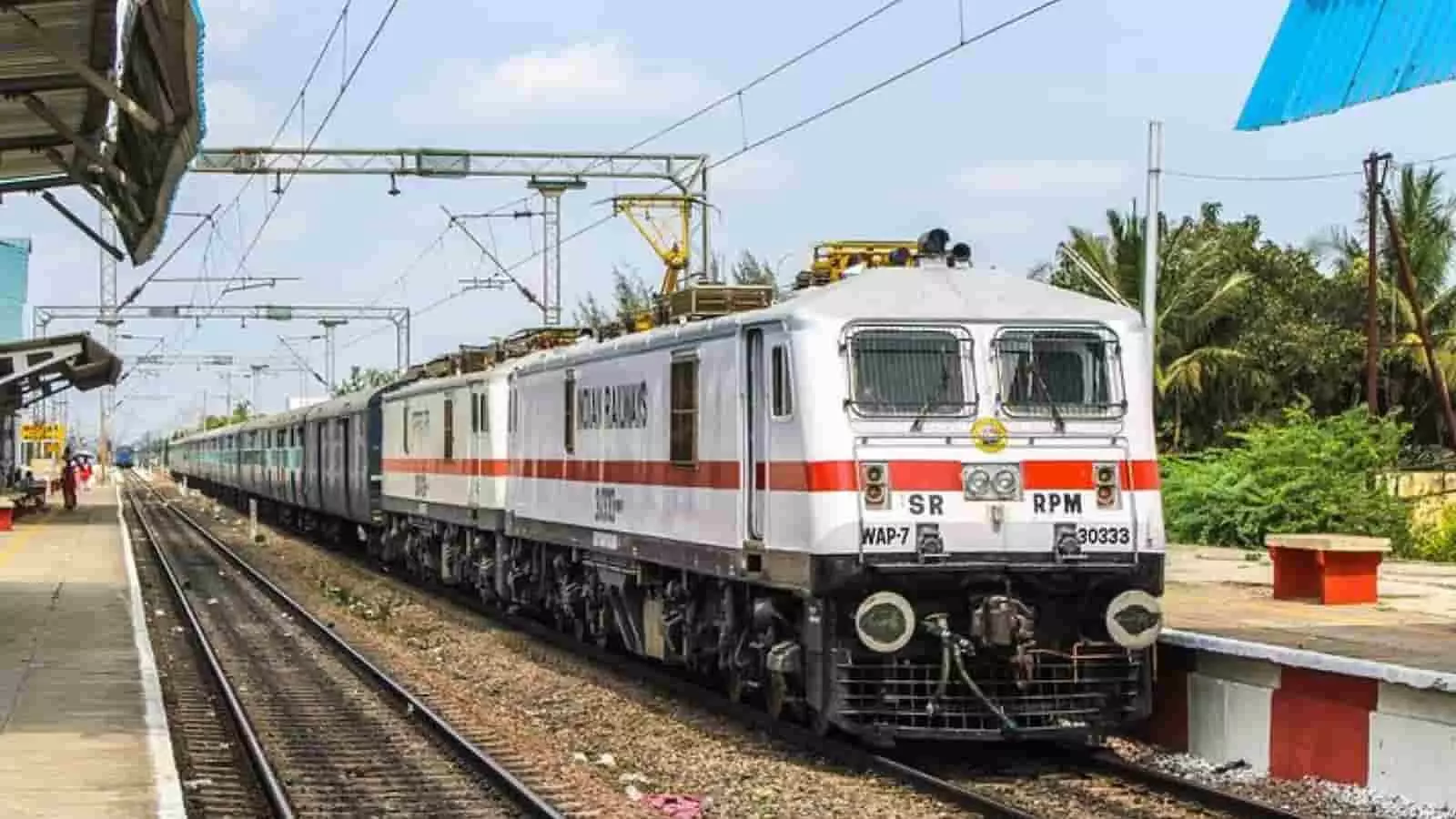 तस्वीर में रेलवे स्टेशन के ट्रैक पर खड़ी एक पैसेंजर ट्रेन दिखाई दे रही है। तस्वीर में रेलवे स्टेशन के ट्रैक पर खड़ी एक पैसेंजर ट्रेन दिखाई दे रही है।