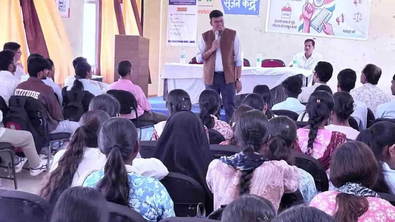 तस्वीर में कॉलेज सभागार में विद्यार्थियों के सामने खड़े होकर संबोधित करते हुए अधिकारी और पीछे बैनर दिखाई दे रहा है। तस्वीर में कॉलेज सभागार में विद्यार्थियों के सामने खड़े होकर संबोधित करते हुए अधिकारी और पीछे बैनर दिखाई दे रहा है।