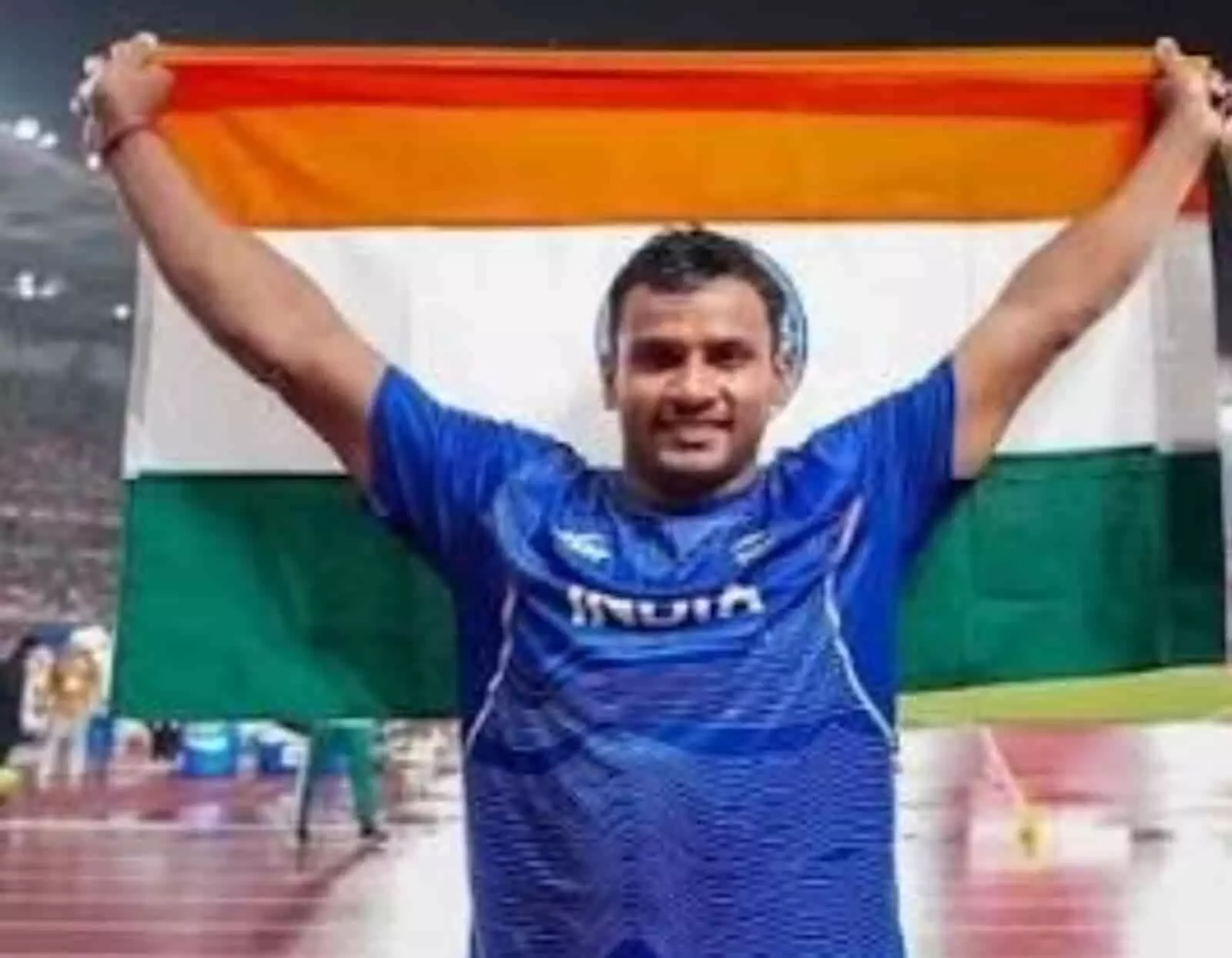 तस्वीर में खिलाड़ी यशवीर सिंह नीली जर्सी पहने हुए दोनों हाथों से तिरंगा झंडा पकड़े खड़े हैं। तस्वीर में खिलाड़ी यशवीर सिंह नीली जर्सी पहने हुए दोनों हाथों से तिरंगा झंडा पकड़े खड़े हैं।