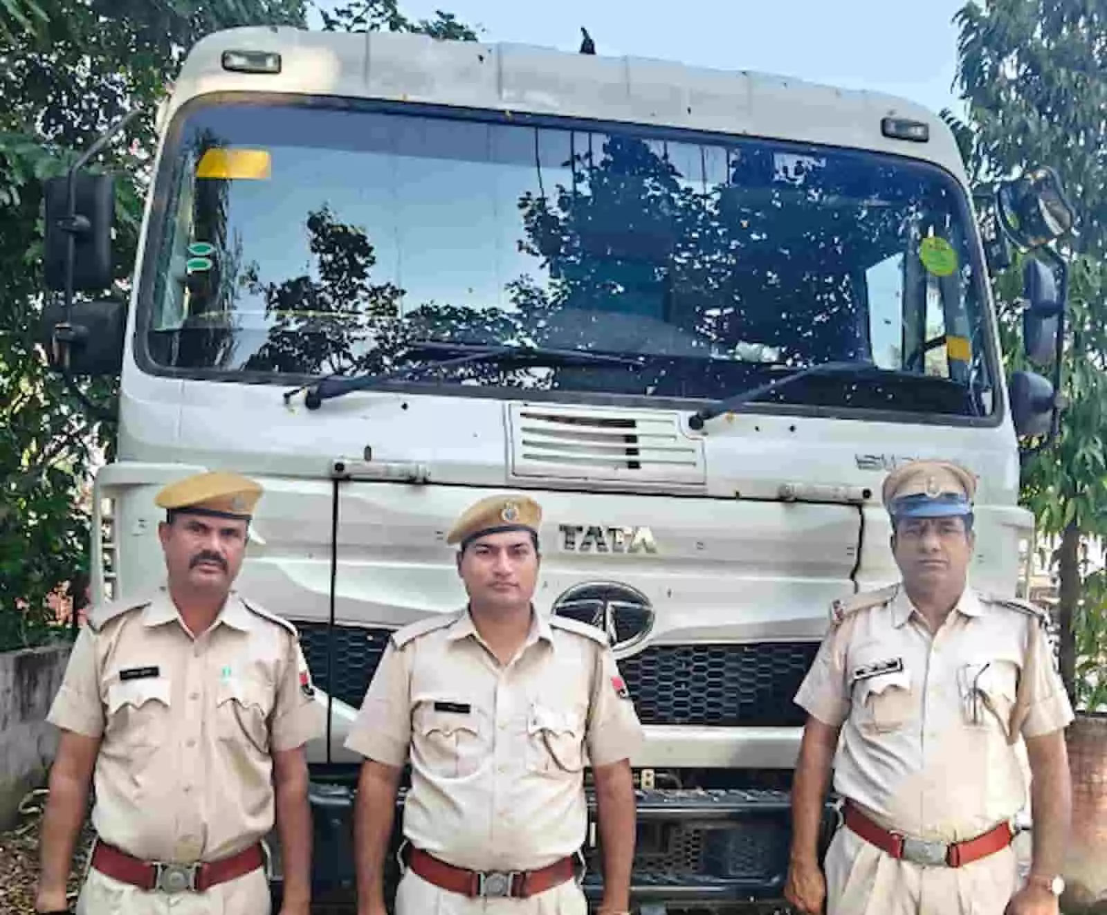 तस्वीर में तीन पुलिसकर्मी बरामद डंपर के सामने खड़े हैं। तस्वीर में तीन पुलिसकर्मी बरामद डंपर के सामने खड़े हैं।