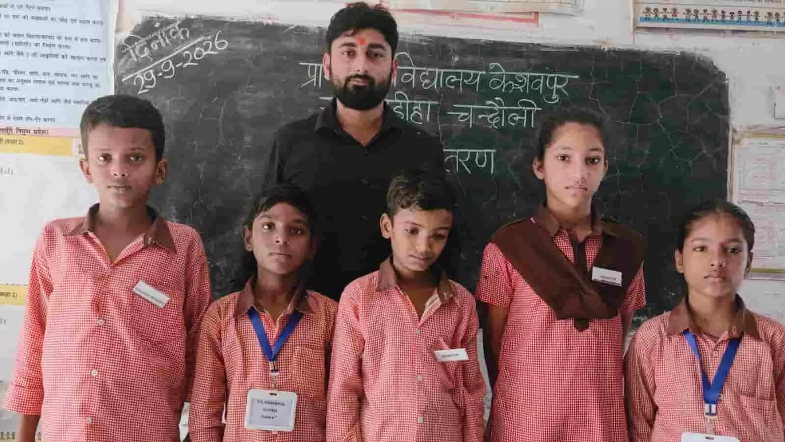 तस्वीर में प्राथमिक विद्यालय केशवपुर चंदौली में शिक्षक और विद्यार्थी बैज पहने खड़े हैं। तस्वीर में प्राथमिक विद्यालय केशवपुर चंदौली में शिक्षक और विद्यार्थी बैज पहने खड़े हैं।