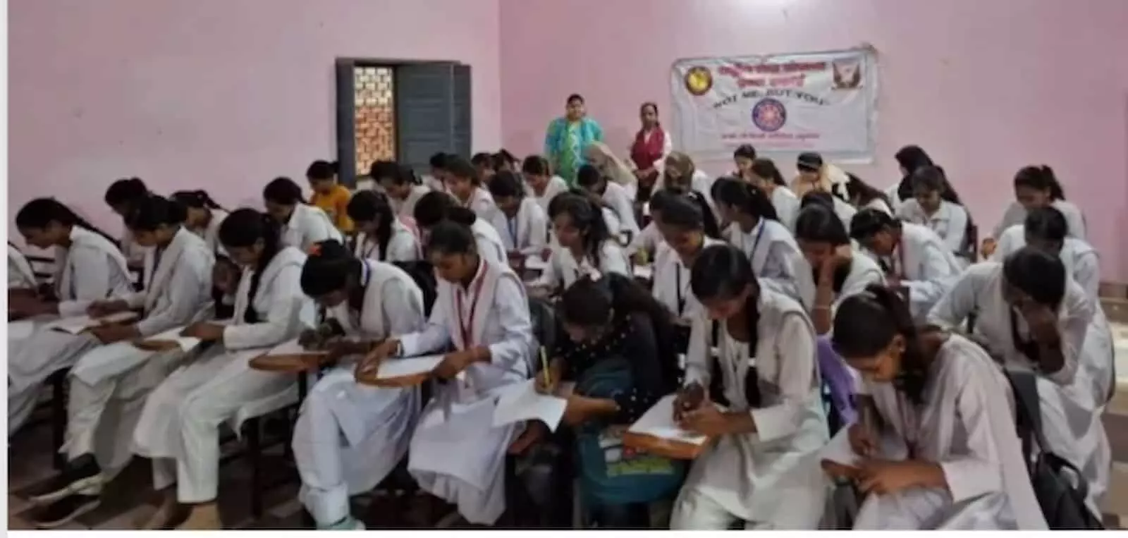 तस्वीर में दिख रही छात्राएं कमरे में बैठकर राष्ट्रीय सेवा योजना बैनर के सामने प्रश्न पत्र हल कर रही हैं। तस्वीर में दिख रही छात्राएं कमरे में बैठकर राष्ट्रीय सेवा योजना बैनर के सामने प्रश्न पत्र हल कर रही हैं।