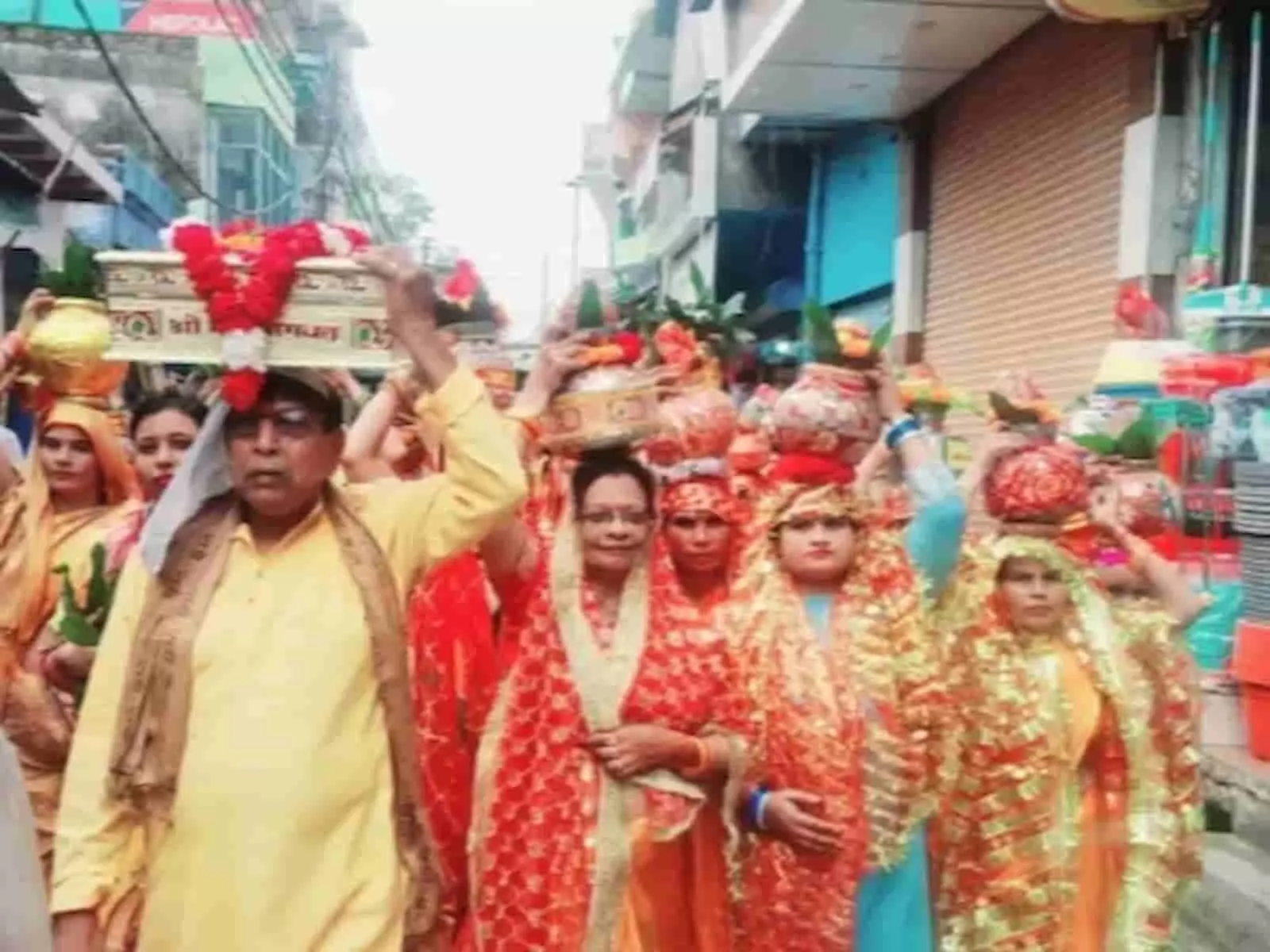 तस्वीर में दिख रही महिलाएं पारंपरिक पोशाक में सिर पर मंगल कलश धारण कर सड़क पर चलती नजर आ रही हैं। तस्वीर में दिख रही महिलाएं पारंपरिक पोशाक में सिर पर मंगल कलश धारण कर सड़क पर चलती नजर आ रही हैं।