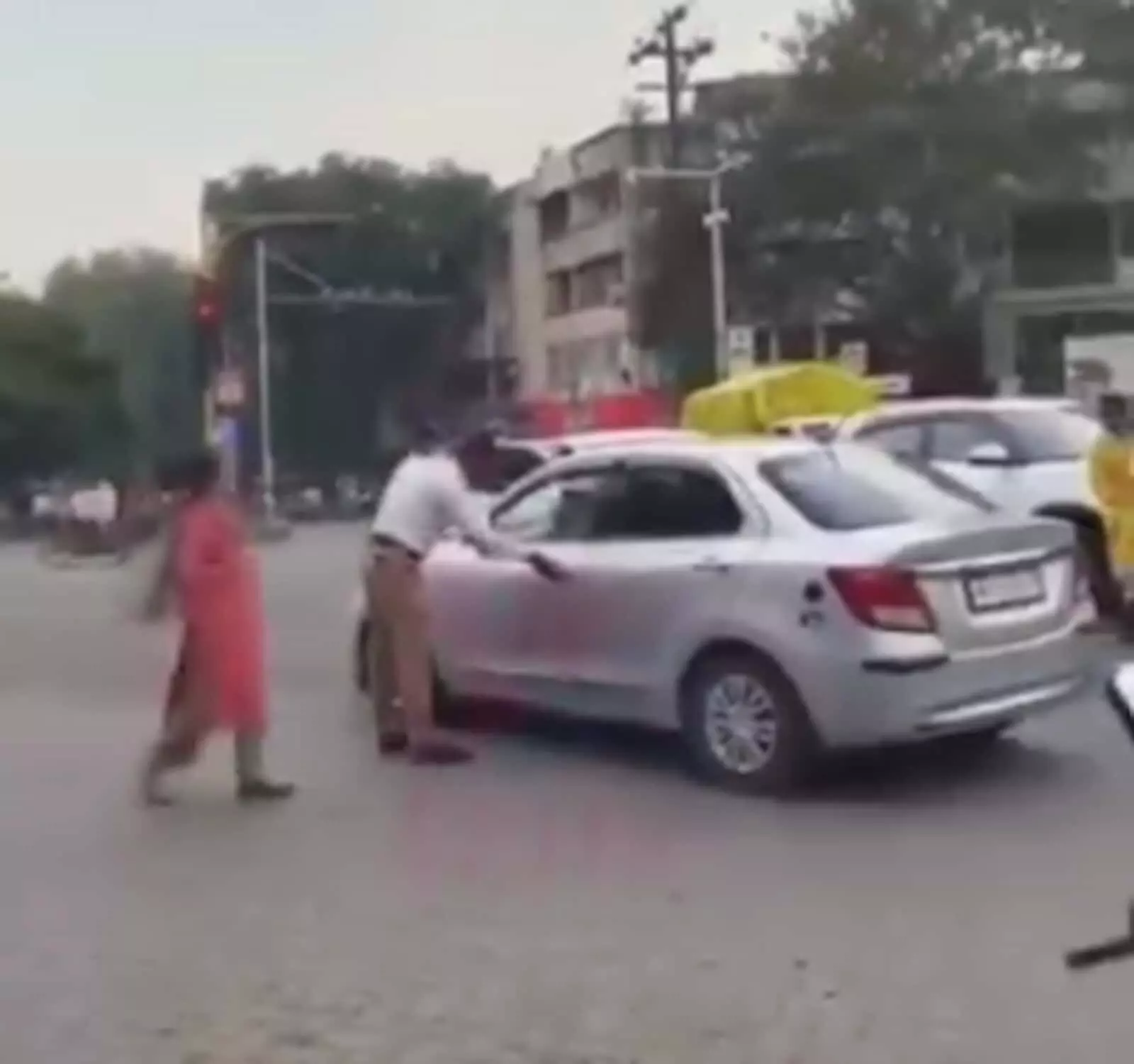 तस्वीर में ट्रैफिक पुलिस हवलदार सड़क पर कार को रोकने के लिए उसके पास खड़ा है। तस्वीर में ट्रैफिक पुलिस हवलदार सड़क पर कार को रोकने के लिए उसके पास खड़ा है।