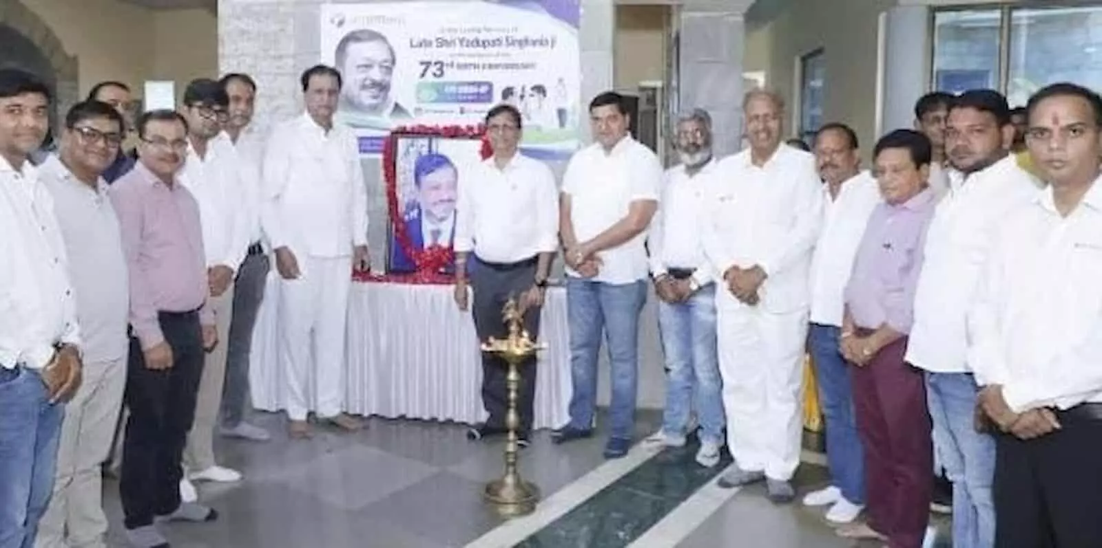 तस्वीर में अतिथि और अधिकारी निंबाहेड़ा में यदुपति सिंघानिया की तस्वीर के पास खड़े हैं। तस्वीर में अतिथि और अधिकारी निंबाहेड़ा में यदुपति सिंघानिया की तस्वीर के पास खड़े हैं।