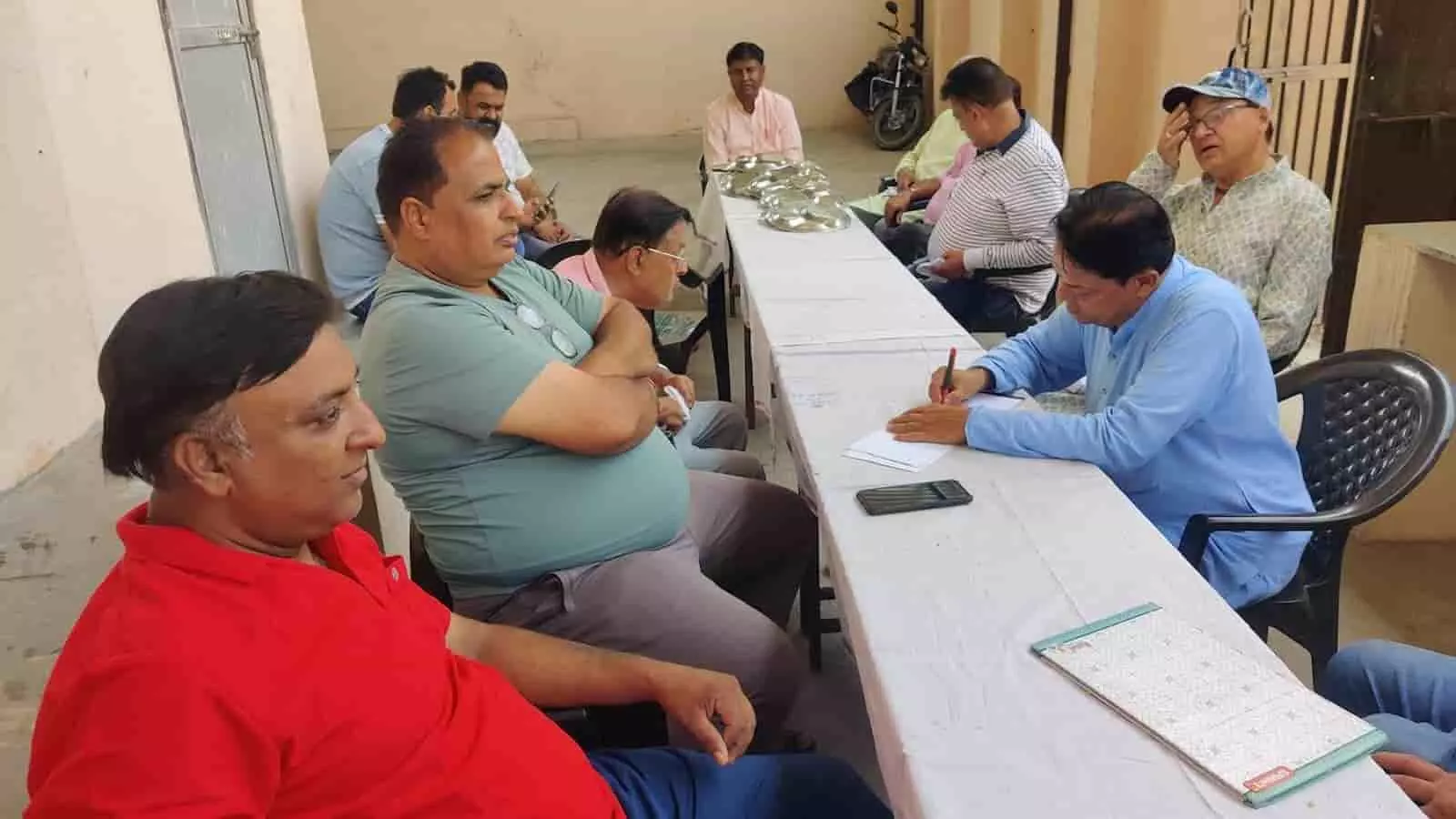 तस्वीर में बाईं से दाईं ओर बैठे पदाधिकारी एक लंबी मेज पर बैठकर बैठक में भाग ले रहे हैं। तस्वीर में बाईं से दाईं ओर बैठे पदाधिकारी एक लंबी मेज पर बैठकर बैठक में भाग ले रहे हैं।
