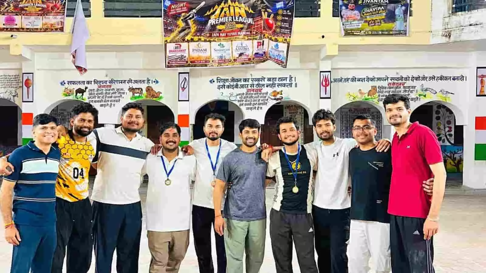 तस्वीर में जैन प्रीमियर लीग के खिलाड़ी ट्रॉफी और बैट के साथ खड़े हैं। तस्वीर में जैन प्रीमियर लीग के खिलाड़ी ट्रॉफी और बैट के साथ खड़े हैं।