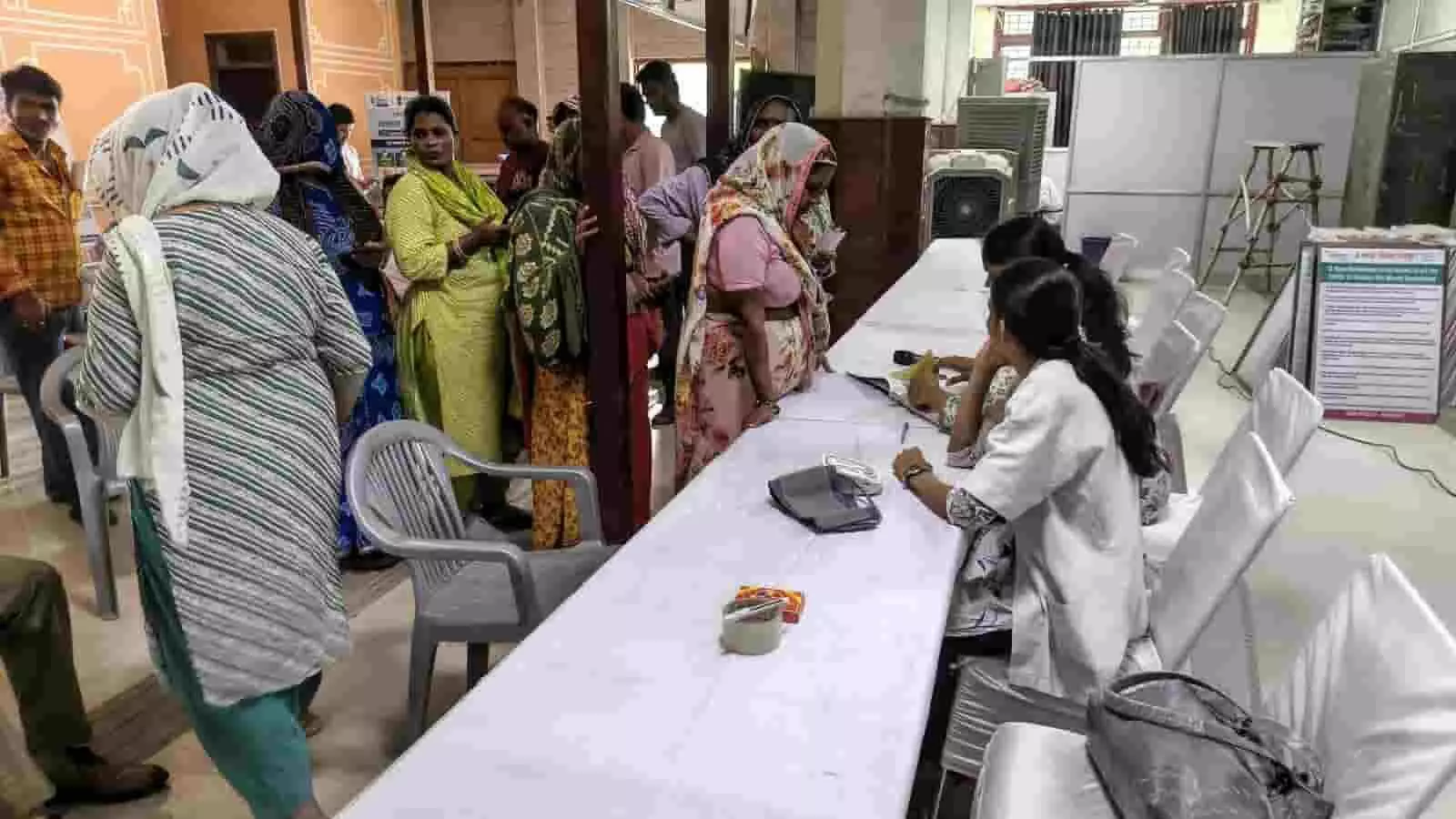 जयपुर में आयोजित स्वास्थ्य जांच शिविर में कतार में खड़े लोग और डॉक्टर। जयपुर में आयोजित स्वास्थ्य जांच शिविर में कतार में खड़े लोग और डॉक्टर।
