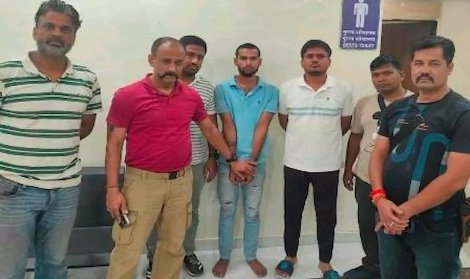तस्वीर में पुलिस टीम के साथ नीली टी-शर्ट पहने आरोपी लादूराम बीच में खड़ा दिखाई दे रहा है। तस्वीर में पुलिस टीम के साथ नीली टी-शर्ट पहने आरोपी लादूराम बीच में खड़ा दिखाई दे रहा है।