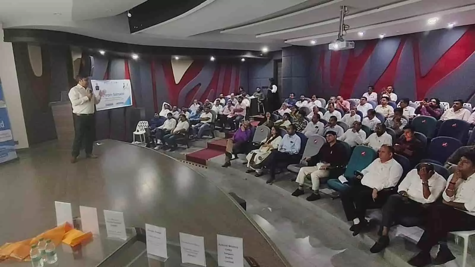 तस्वीर में सभागार में मंच पर एक वक्ता और सामने कुर्सियों पर बैठे प्रतिभागी दिख रहे हैं। तस्वीर में सभागार में मंच पर एक वक्ता और सामने कुर्सियों पर बैठे प्रतिभागी दिख रहे हैं।