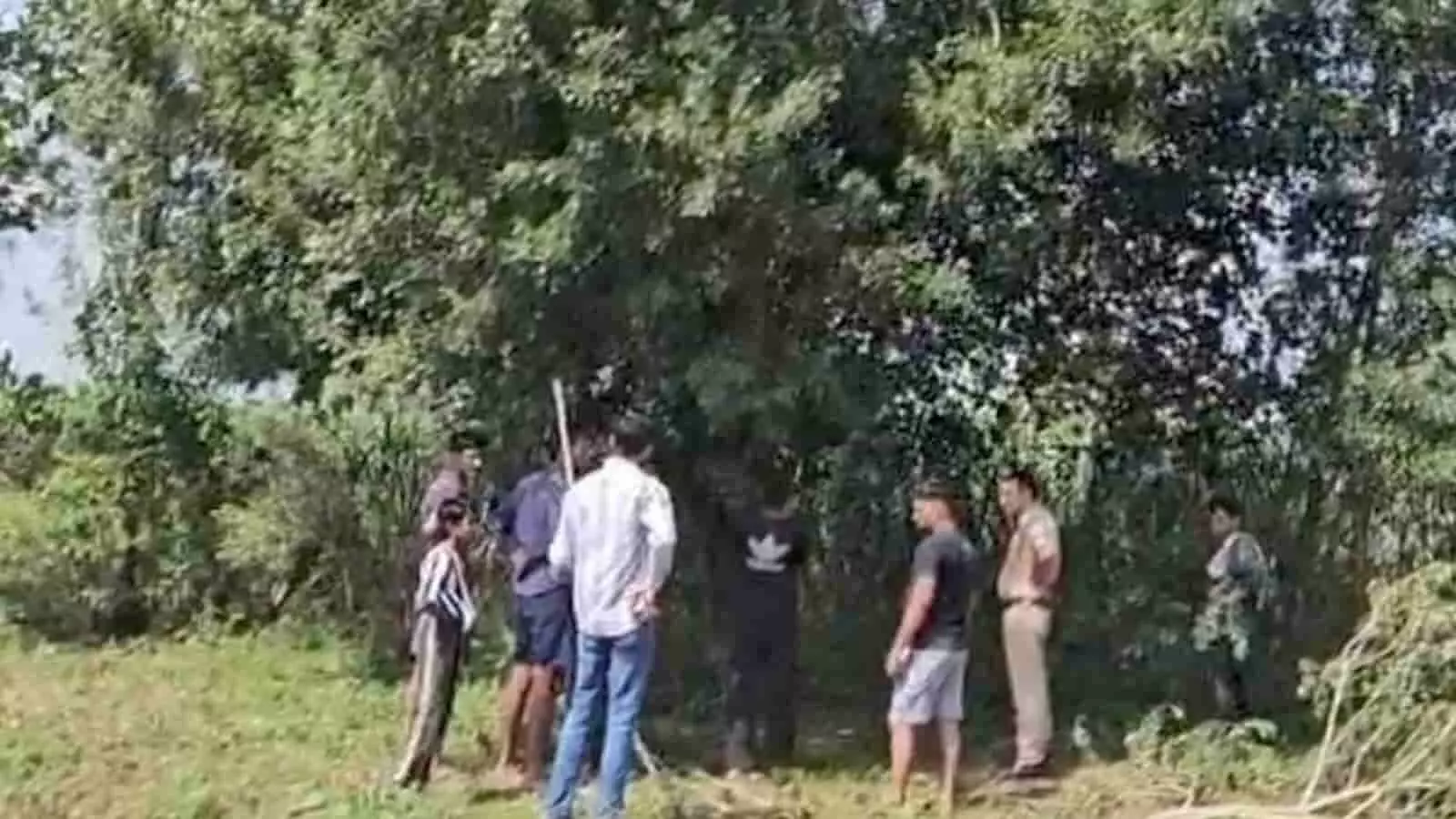 तस्वीर में गढ़मुक्तेश्वर के जंगल में पेड़ के पास खड़े ग्रामीण और पुलिसकर्मी दिखाई दे रहे हैं। तस्वीर में गढ़मुक्तेश्वर के जंगल में पेड़ के पास खड़े ग्रामीण और पुलिसकर्मी दिखाई दे रहे हैं।