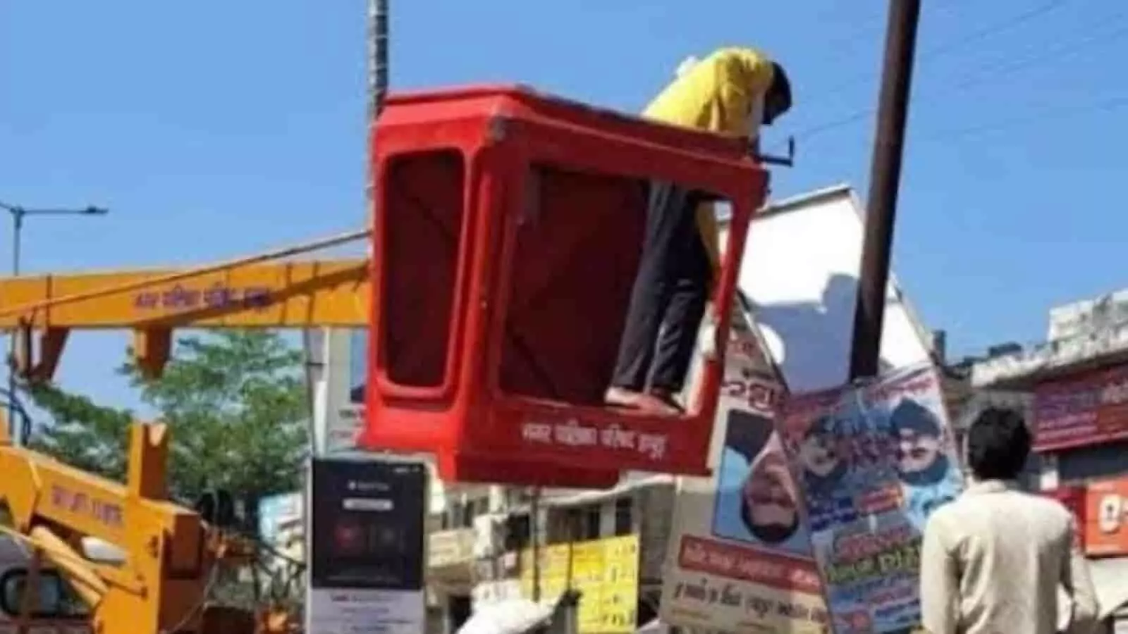 तस्वीर में क्रेन की लाल टोकरी में खड़े होकर कर्मचारी हापुड़ में अवैध होर्डिंग हटा रहे हैं। तस्वीर में क्रेन की लाल टोकरी में खड़े होकर कर्मचारी हापुड़ में अवैध होर्डिंग हटा रहे हैं।