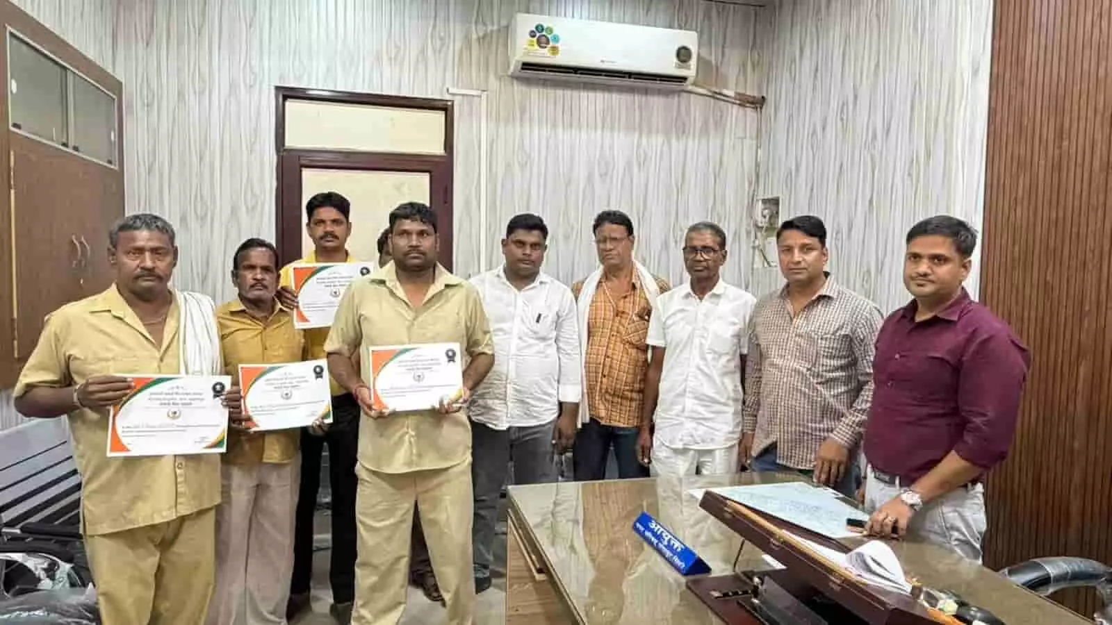 तस्वीर में नगर परिषद कार्यालय के भीतर अधिकारी और सम्मान पत्र हाथ में लिए सफाई मित्र खड़े दिख रहे हैं। तस्वीर में नगर परिषद कार्यालय के भीतर अधिकारी और सम्मान पत्र हाथ में लिए सफाई मित्र खड़े दिख रहे हैं।