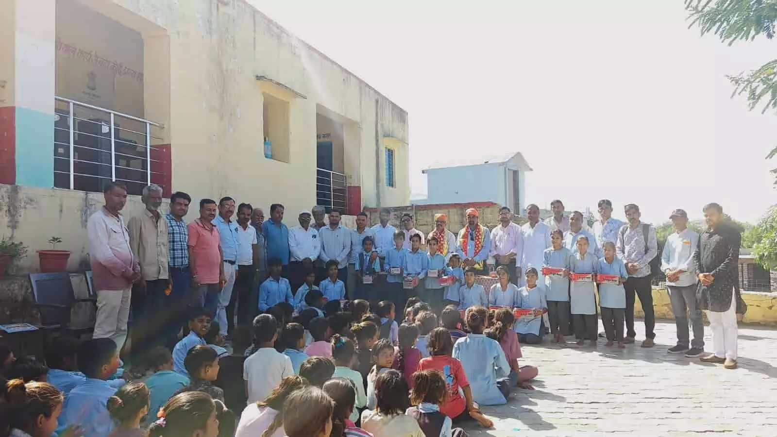 विद्यालय परिसर में शिक्षक और अतिथियों के साथ खड़े स्कूली बच्चे जूता-मोजा के डिब्बे हाथ में लिए दिख रहे हैं। विद्यालय परिसर में शिक्षक और अतिथियों के साथ खड़े स्कूली बच्चे जूता-मोजा के डिब्बे हाथ में लिए दिख रहे हैं।