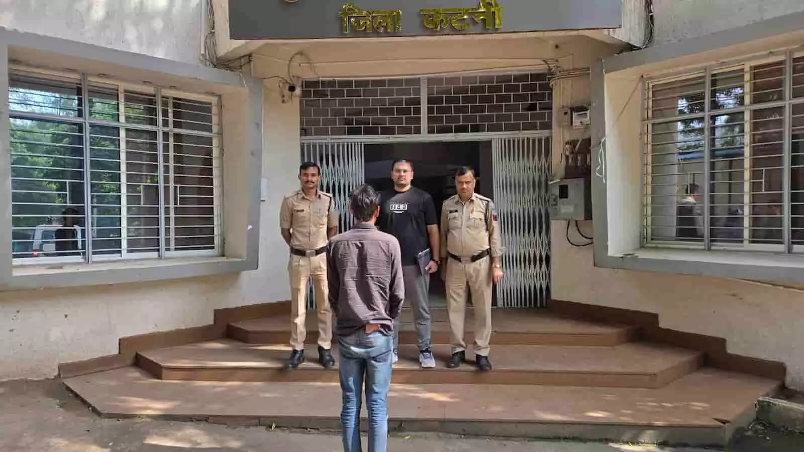 तस्वीर में बाएं से दाएं दो पुलिसकर्मी, काली टी-शर्ट पहने एक व्यक्ति और पीछे की ओर मुंह करके खड़ा आरोपी दिख रहे हैं। तस्वीर में बाएं से दाएं दो पुलिसकर्मी, काली टी-शर्ट पहने एक व्यक्ति और पीछे की ओर मुंह करके खड़ा आरोपी दिख रहे हैं।