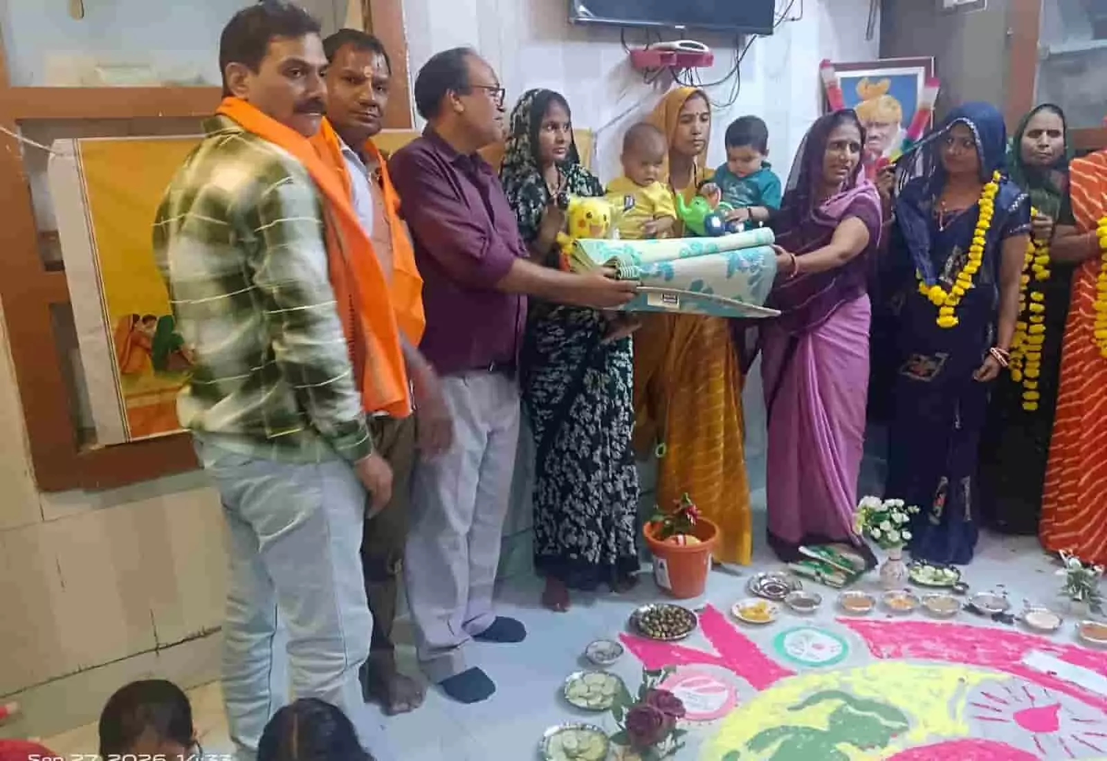 तस्वीर में आंगनबाड़ी केंद्र के अंदर पुरुष और महिलाएं बच्चों के लिए फर्श चटाई और खिलौने पकड़े हुए खड़े हैं। तस्वीर में आंगनबाड़ी केंद्र के अंदर पुरुष और महिलाएं बच्चों के लिए फर्श चटाई और खिलौने पकड़े हुए खड़े हैं।