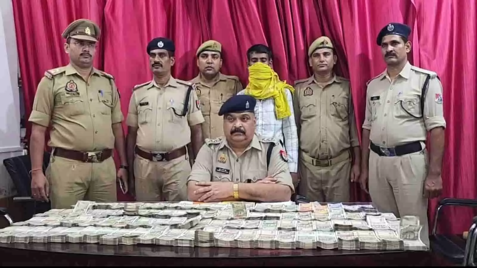 तस्वीर में पुलिसकर्मी बरामद नकदी और एक संदिग्ध व्यक्ति के साथ खड़े हैं। तस्वीर में पुलिसकर्मी बरामद नकदी और एक संदिग्ध व्यक्ति के साथ खड़े हैं।