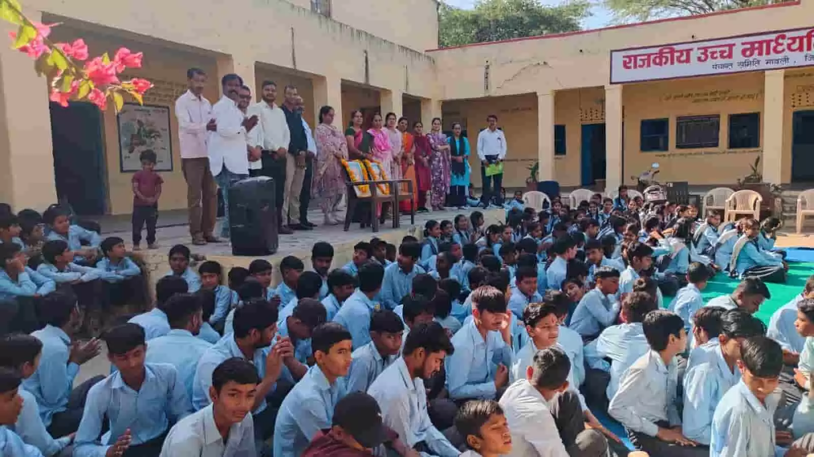 तस्वीर में राजकीय विद्यालय परिसर के बरामदे पर खड़े शिक्षक और जमीन पर बैठे विद्यार्थी नजर आ रहे हैं। तस्वीर में राजकीय विद्यालय परिसर के बरामदे पर खड़े शिक्षक और जमीन पर बैठे विद्यार्थी नजर आ रहे हैं।
