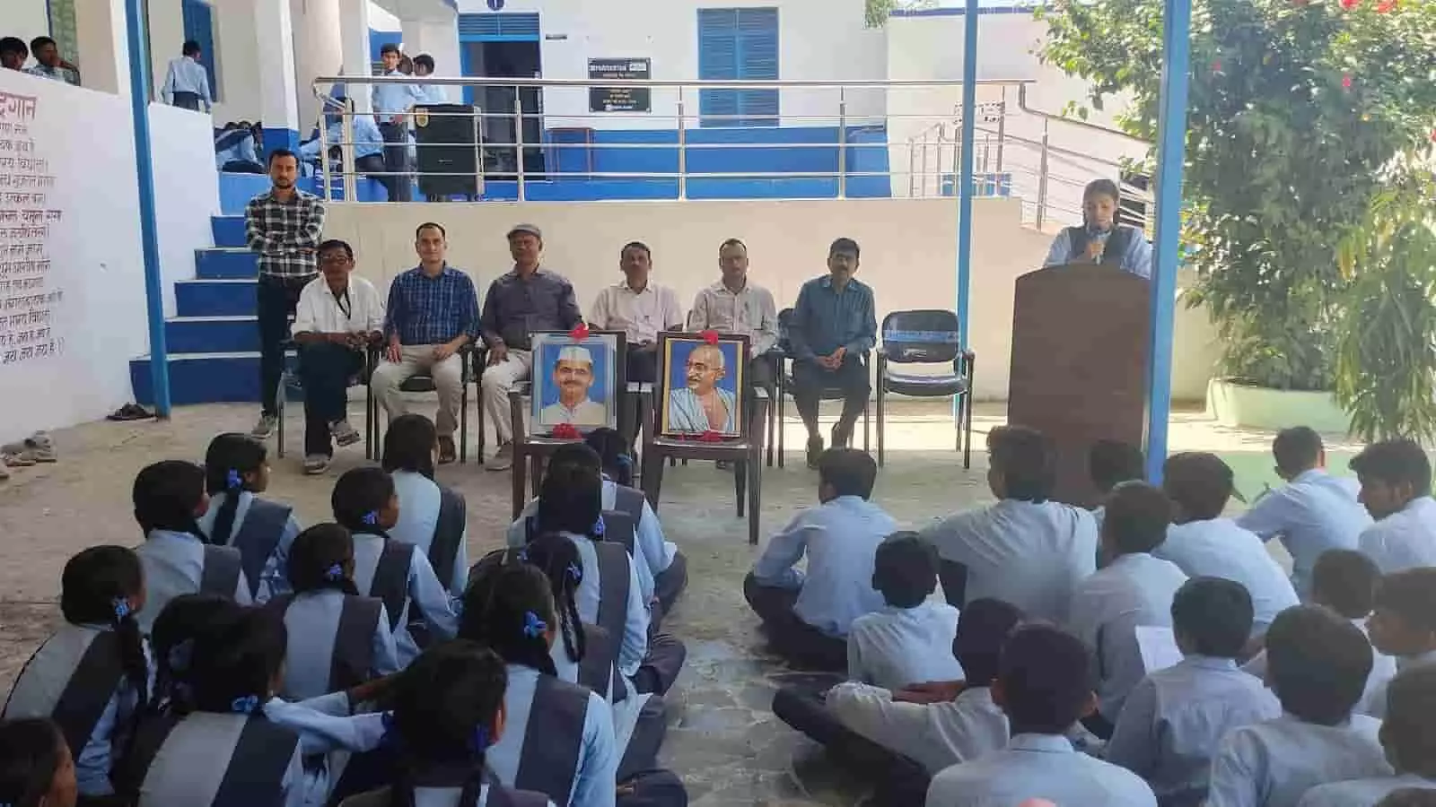 तस्वीर में महात्मा गांधी और लाल बहादुर शास्त्री के चित्रों के सामने शिक्षक एवं विद्यार्थी उपस्थित हैं। तस्वीर में महात्मा गांधी और लाल बहादुर शास्त्री के चित्रों के सामने शिक्षक एवं विद्यार्थी उपस्थित हैं।