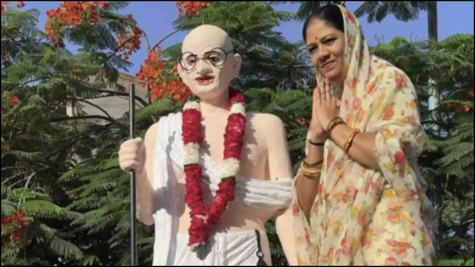 तस्वीर में महात्मा गांधी की प्रतिमा के पास एक महिला हाथ जोड़कर खड़ी दिख रही है। तस्वीर में महात्मा गांधी की प्रतिमा के पास एक महिला हाथ जोड़कर खड़ी दिख रही है।