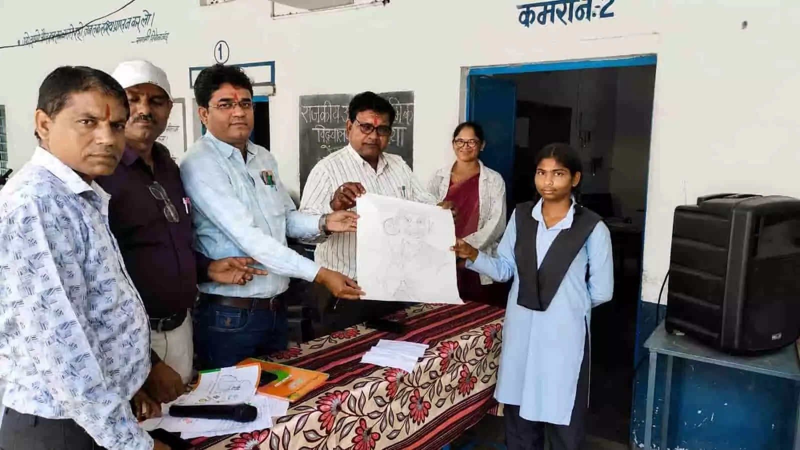 तस्वीर में स्कूल के शिक्षक और छात्रा बंजारिया विद्यालय में महात्मा गांधी का स्केच पकड़े हुए हैं। तस्वीर में स्कूल के शिक्षक और छात्रा बंजारिया विद्यालय में महात्मा गांधी का स्केच पकड़े हुए हैं।