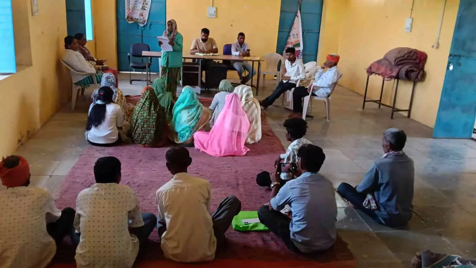 तस्वीर में ग्रामीण विशेष ग्राम सभा की बैठक में फर्श पर बैठे हुए दिखाई दे रहे हैं। तस्वीर में ग्रामीण विशेष ग्राम सभा की बैठक में फर्श पर बैठे हुए दिखाई दे रहे हैं।