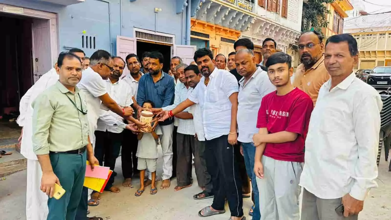 तस्वीर में निकुंभ स्थित एक मकान के बाहर कई पुरुष और बच्चा एक साथ खड़े नजर आ रहे हैं। तस्वीर में निकुंभ स्थित एक मकान के बाहर कई पुरुष और बच्चा एक साथ खड़े नजर आ रहे हैं।