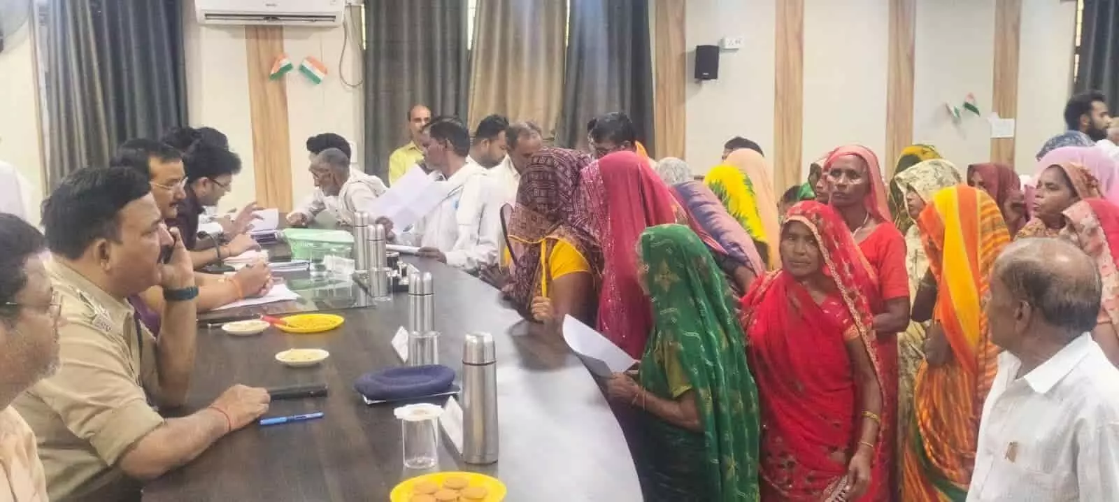 तस्वीर में दिख रही महिलाएं और पुरुष अधिकारी की मेज के पास खड़े होकर ज्ञापन दे रहे हैं। तस्वीर में दिख रही महिलाएं और पुरुष अधिकारी की मेज के पास खड़े होकर ज्ञापन दे रहे हैं।