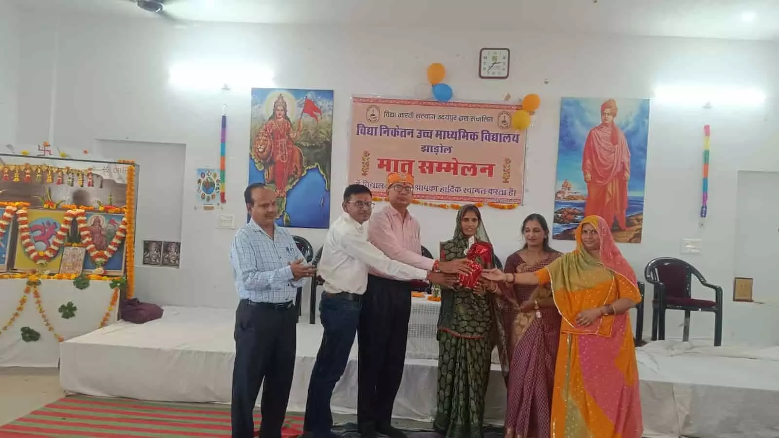 तस्वीर में मातृ सम्मेलन के बैनर के आगे अतिथि और आयोजक एक महिला को पुरस्कार भेंट कर रहे हैं। तस्वीर में मातृ सम्मेलन के बैनर के आगे अतिथि और आयोजक एक महिला को पुरस्कार भेंट कर रहे हैं।