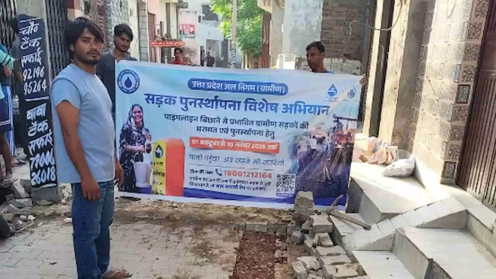 तस्वीर में ग्रामीण उत्तर प्रदेश जल निगम (ग्रामीण) के सड़क पुनर्रस्थापना विशेष अभियान का बैनर पकड़े हुए दिखाई दे रहे हैं। तस्वीर में ग्रामीण उत्तर प्रदेश जल निगम (ग्रामीण) के सड़क पुनर्रस्थापना विशेष अभियान का बैनर पकड़े हुए दिखाई दे रहे हैं।