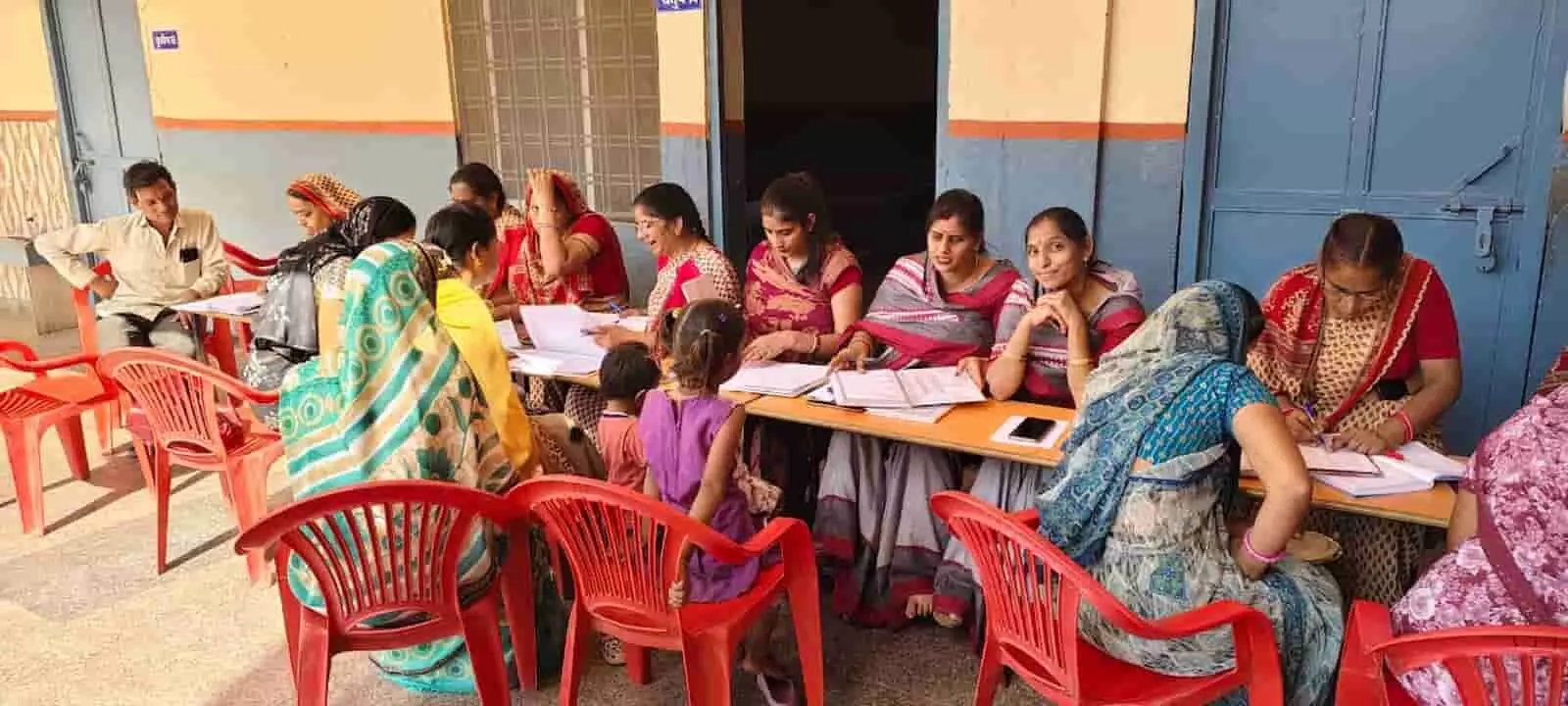 तस्वीर में दिख रही शिक्षिकाएं और अभिभावक मेज के आमने-सामने बैठकर फाइलों की जांच कर रहे हैं। तस्वीर में दिख रही शिक्षिकाएं और अभिभावक मेज के आमने-सामने बैठकर फाइलों की जांच कर रहे हैं।