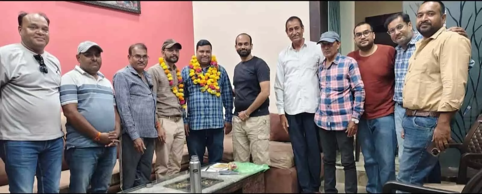तस्वीर में बाएं से दाएं खड़े लोग कमरे में माला पहने अंकुर गालव के साथ हैं। तस्वीर में बाएं से दाएं खड़े लोग कमरे में माला पहने अंकुर गालव के साथ हैं।