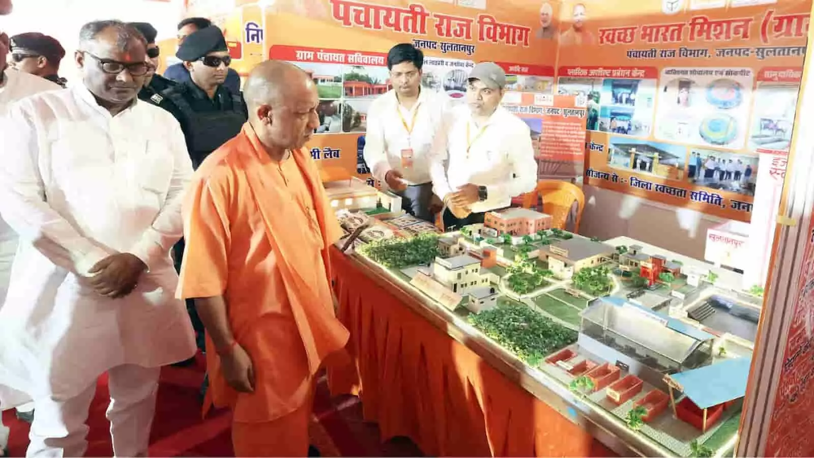 तस्वीर में मुख्यमंत्री योगी आदित्यनाथ अधिकारियों के साथ एक स्टॉल पर मॉडल को ध्यान से देखते हुए खड़े हैं। तस्वीर में मुख्यमंत्री योगी आदित्यनाथ अधिकारियों के साथ एक स्टॉल पर मॉडल को ध्यान से देखते हुए खड़े हैं।