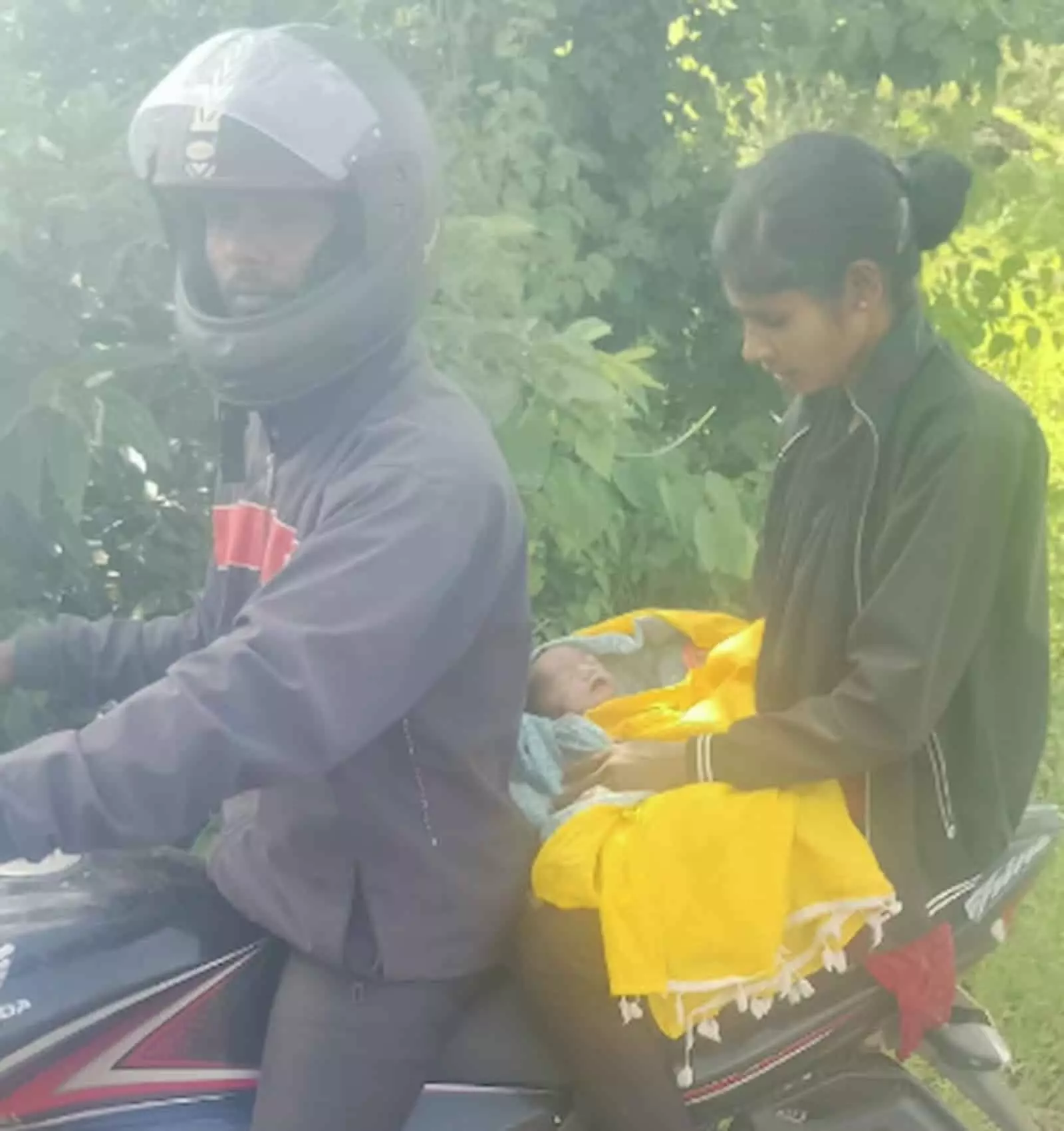 तस्वीर में बाईं ओर हेलमेट पहने व्यक्ति और दाईं ओर महिला बाइक पर बैठकर बच्चे को ले जाते हुए दिख रहे हैं। तस्वीर में बाईं ओर हेलमेट पहने व्यक्ति और दाईं ओर महिला बाइक पर बैठकर बच्चे को ले जाते हुए दिख रहे हैं।