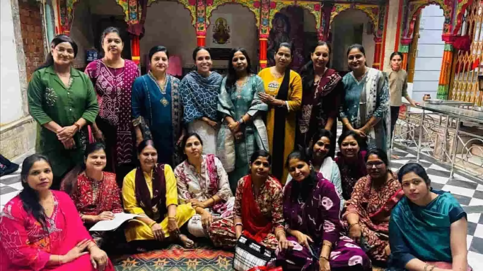 तस्वीर में दिख रही महिलाएं एक परिसर के अंदर सामूहिक फोटो के लिए एक साथ बैठी और खड़ी हैं। तस्वीर में दिख रही महिलाएं एक परिसर के अंदर सामूहिक फोटो के लिए एक साथ बैठी और खड़ी हैं।