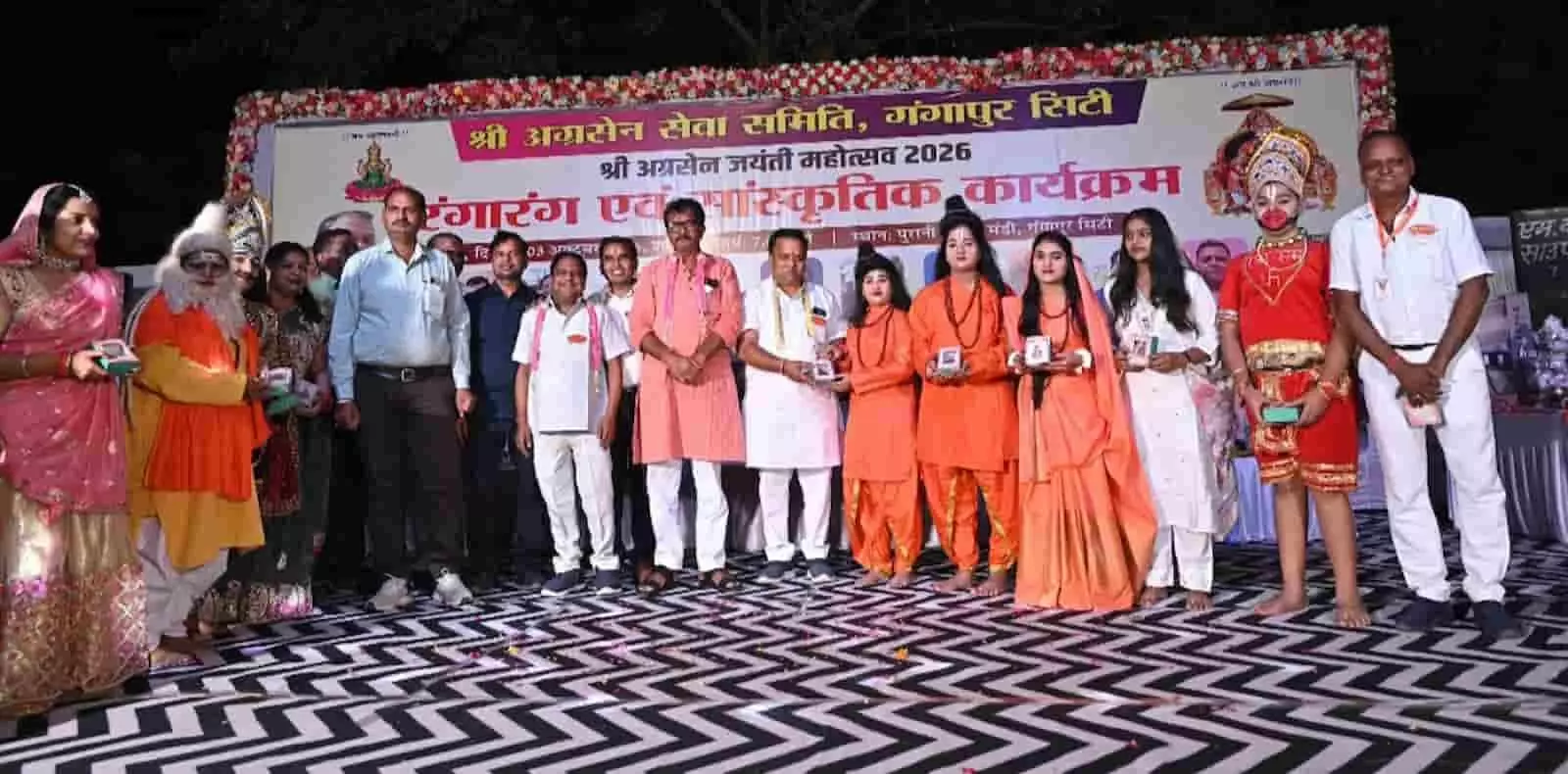 तस्वीर में अग्रसेन मेले के मंच पर पोशाक पहने कलाकार और आयोजक स्मृति चिन्ह लिए खड़े हैं। तस्वीर में अग्रसेन मेले के मंच पर पोशाक पहने कलाकार और आयोजक स्मृति चिन्ह लिए खड़े हैं।