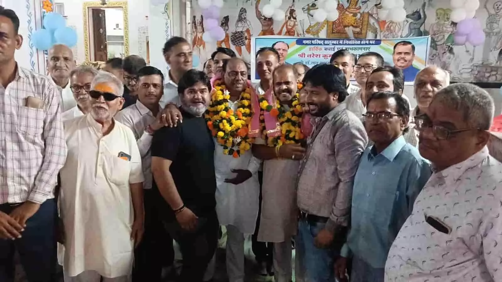 तस्वीर में गेंदे की माला पहने दो नवनिर्वाचित जनप्रतिनिधि अन्य लोगों संग मुस्कुराते हुए खड़े हैं। तस्वीर में गेंदे की माला पहने दो नवनिर्वाचित जनप्रतिनिधि अन्य लोगों संग मुस्कुराते हुए खड़े हैं।