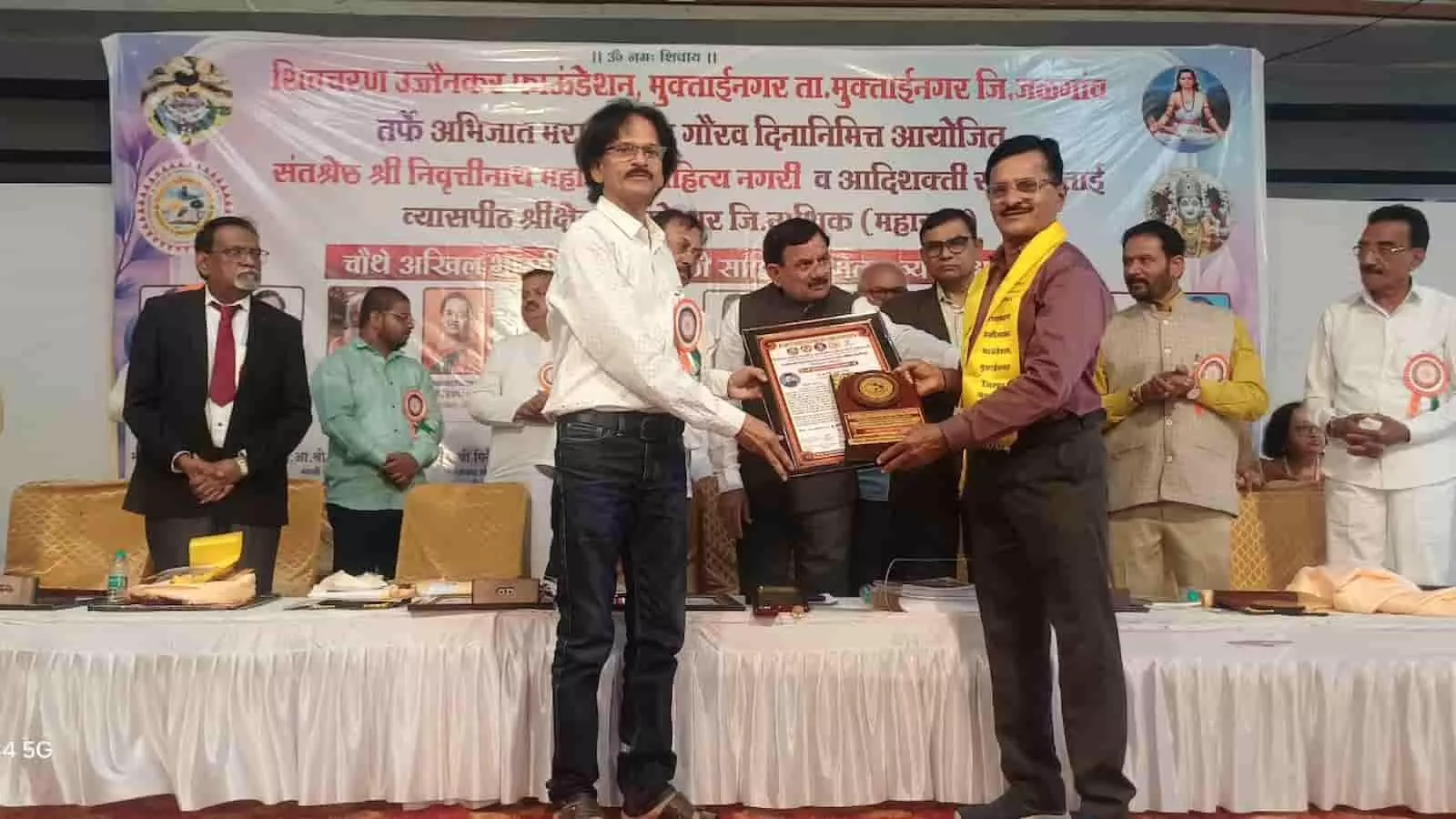 त्र्यंबकेश्वर में आयोजित सम्मेलन के मंच पर प्रा. रवींद्र शिंदे को पुरस्कार दिया जा रहा है। त्र्यंबकेश्वर में आयोजित सम्मेलन के मंच पर प्रा. रवींद्र शिंदे को पुरस्कार दिया जा रहा है।