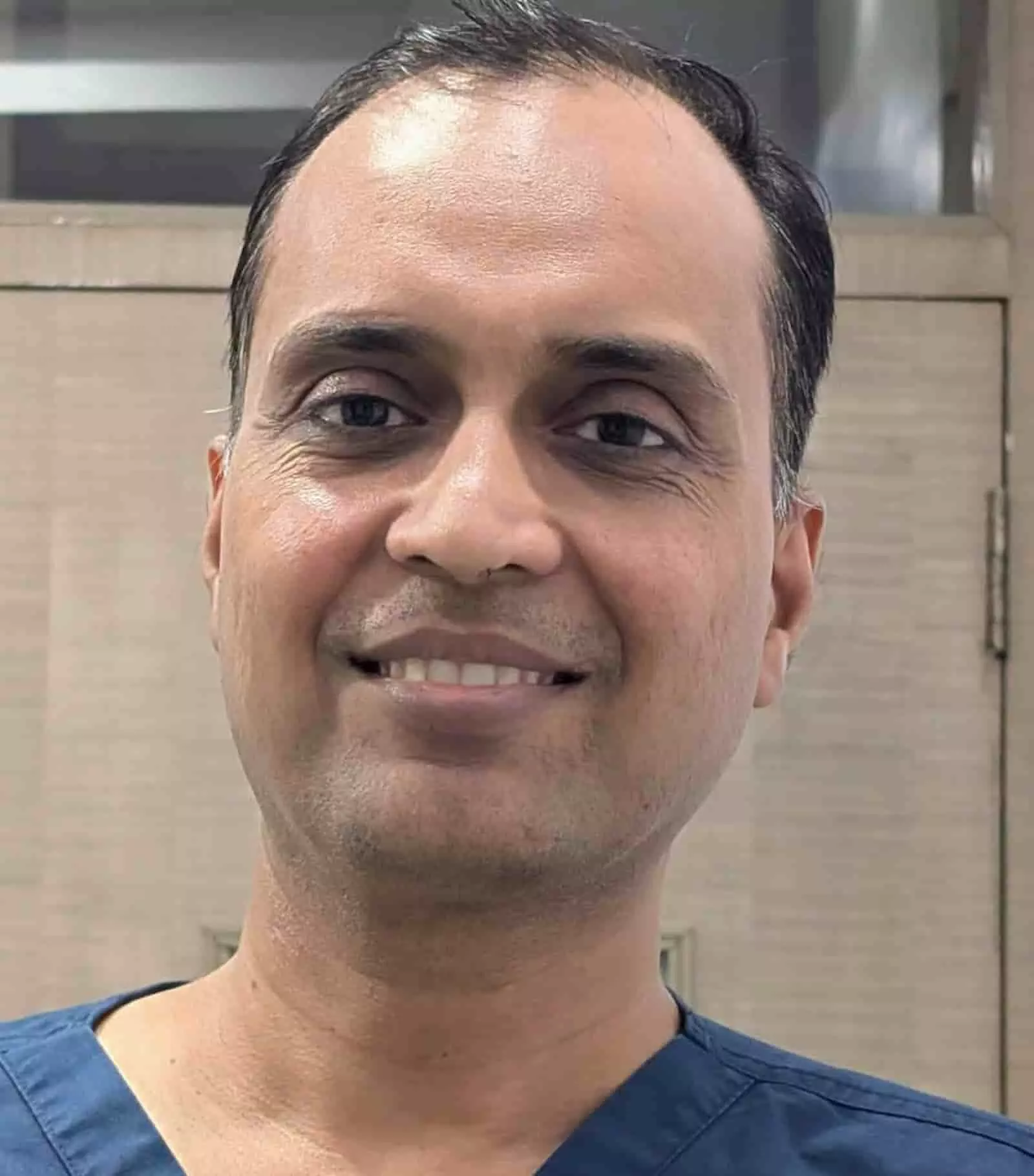 तस्वीर में मेडिकल स्क्रब पहने मुस्कराते हुए डॉ. विनीत जैन कैमरे की ओर देखते दिख रहे हैं। तस्वीर में मेडिकल स्क्रब पहने मुस्कराते हुए डॉ. विनीत जैन कैमरे की ओर देखते दिख रहे हैं।