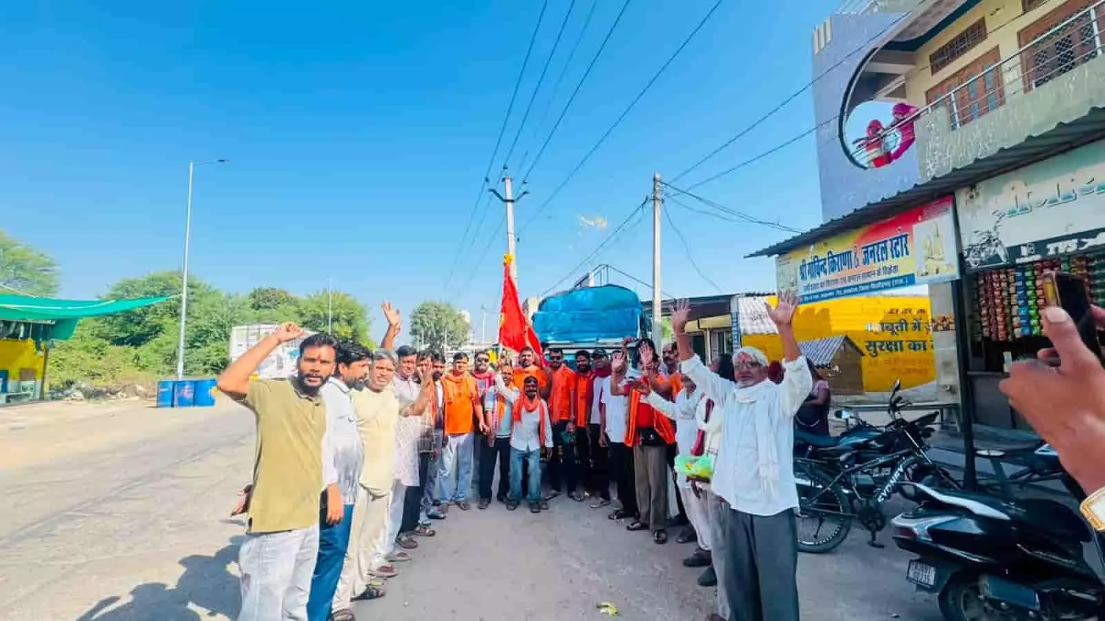 तस्वीर में दिख रही सड़क पर श्रद्धालु धार्मिक यात्रा के दौरान ध्वज थामे अभिवादन कर रहे हैं। तस्वीर में दिख रही सड़क पर श्रद्धालु धार्मिक यात्रा के दौरान ध्वज थामे अभिवादन कर रहे हैं।