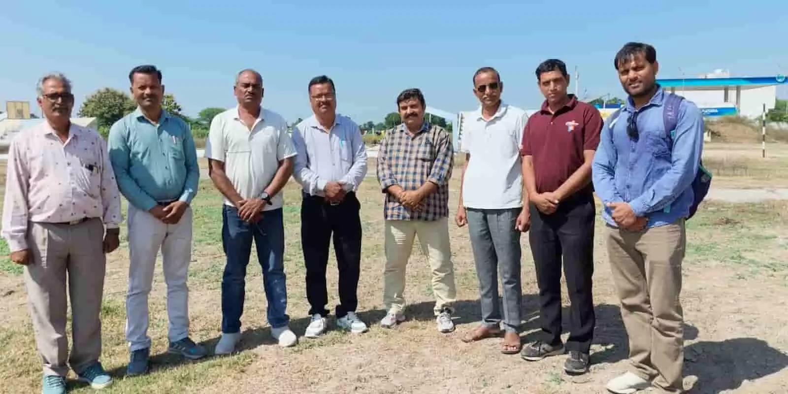 तस्वीर में आठ लोग खुले खेल के मैदान में एक कतार में खड़े होकर चर्चा कर रहे हैं। तस्वीर में आठ लोग खुले खेल के मैदान में एक कतार में खड़े होकर चर्चा कर रहे हैं।
